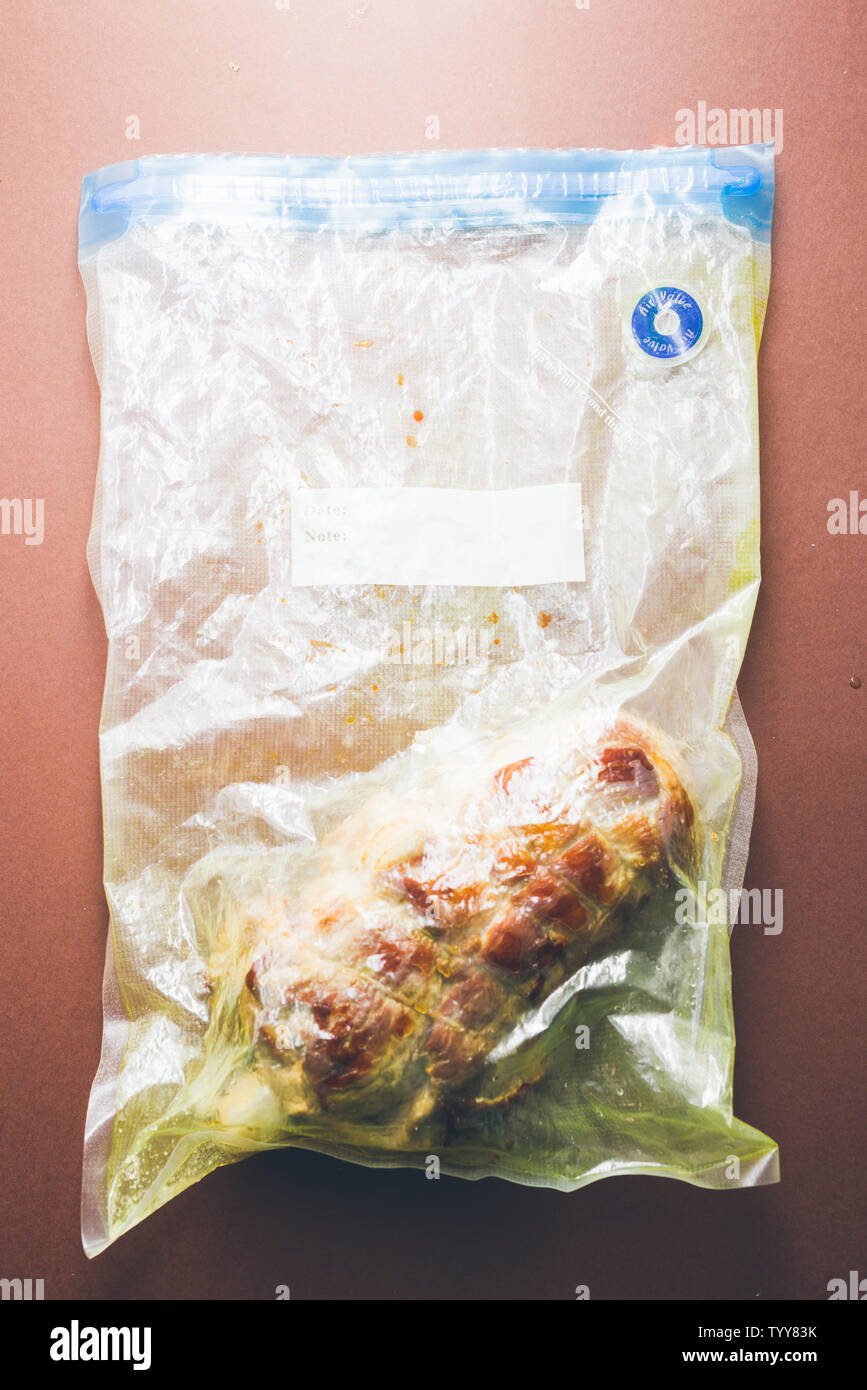 La viande cru roastbeef, préparé avec de la graisse de porc caparisoned caul et le romarin dans un sac sous vide prêts à être cuisinés avec un rooner , vue de dessus plus un br Banque D'Images