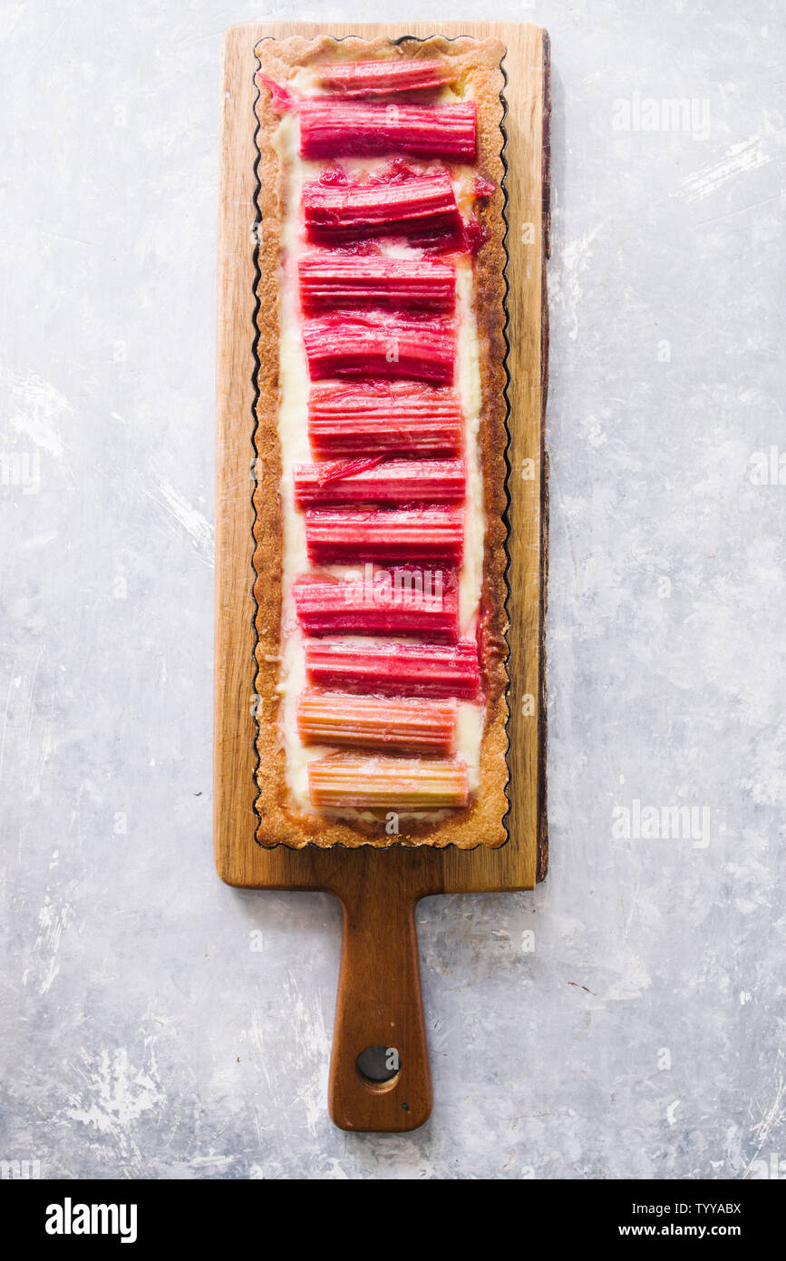 Tarte à la rhubarbe avec une forme rectangulaire, avec une croûte italien une crème pâtissière au citron goût caramélisé et tiges de rhubarbe alignés verticalement, haut Banque D'Images