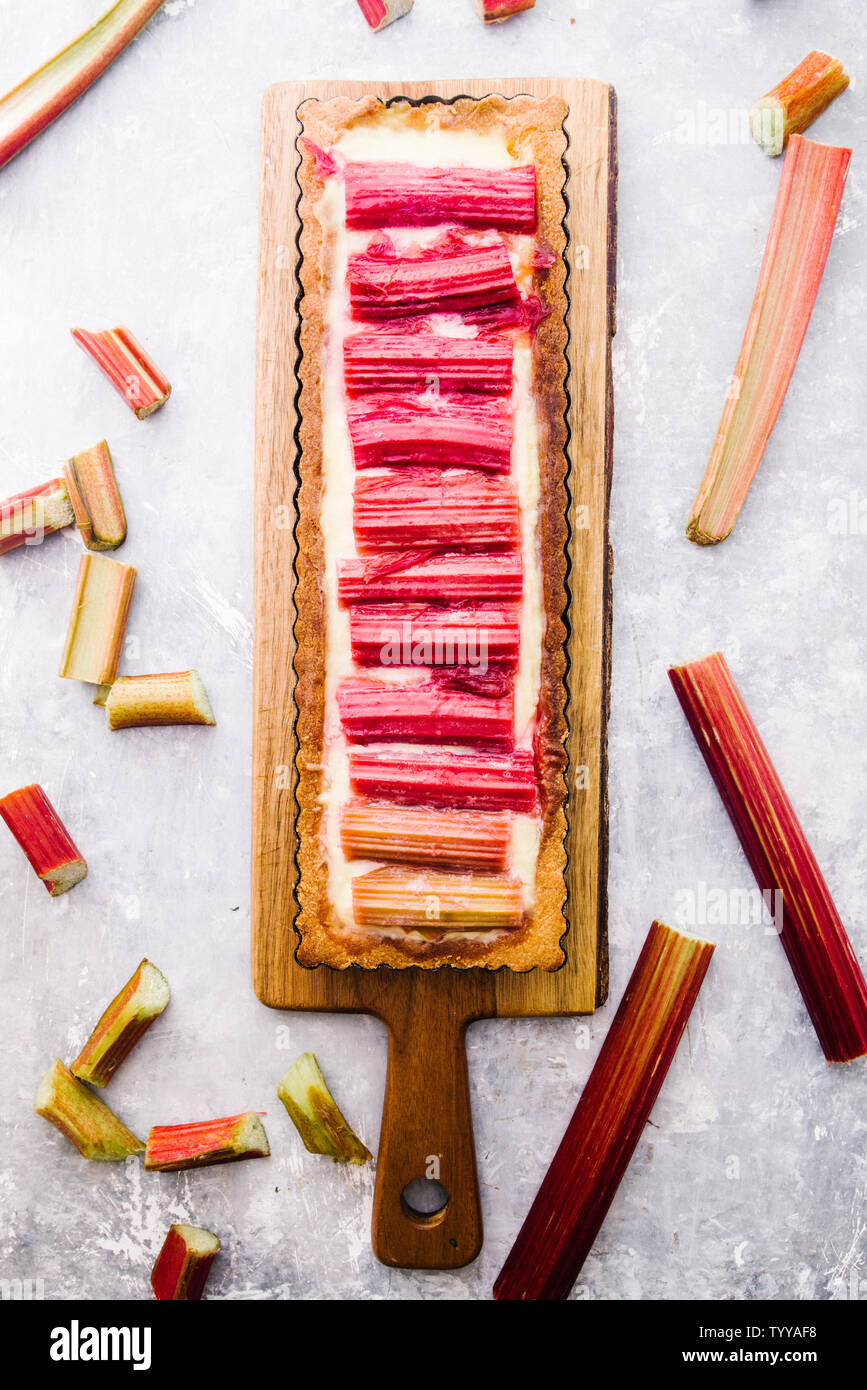 Tarte à la rhubarbe avec une forme rectangulaire, avec une croûte italien une crème pâtissière au citron goût caramélisé et alignés verticalement et tiges de rhubarbe Banque D'Images