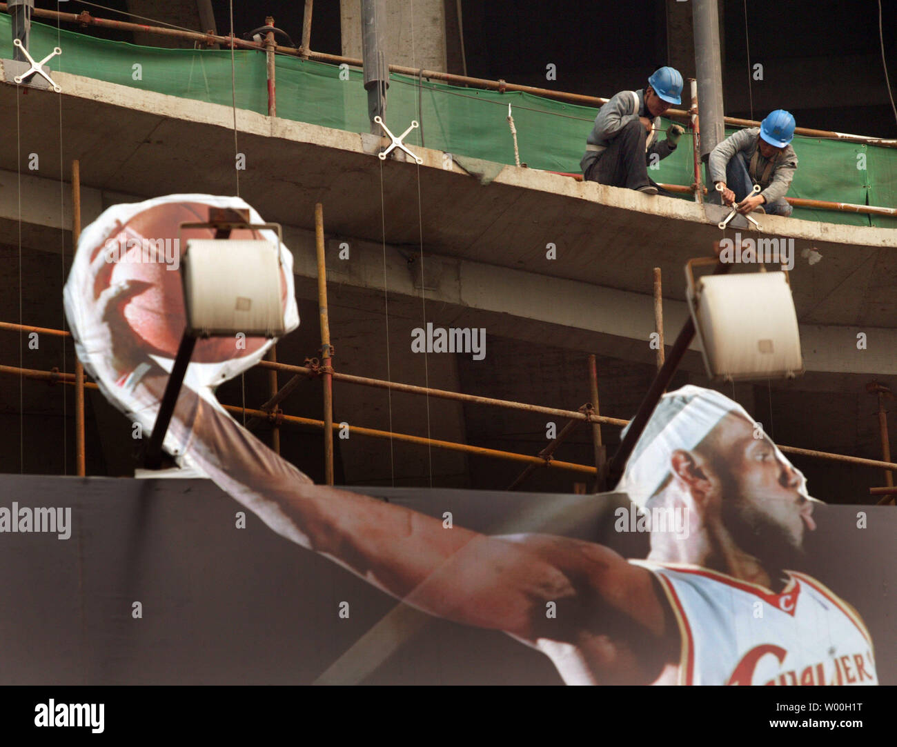 Ouvriers chinois travaillent sur site de construction massive derrière un  panneau, la Chine Nike NBA d' étoiles pour promouvoir la dernière ligne de  sports, au centre-ville du quartier commerçant de Beijing le