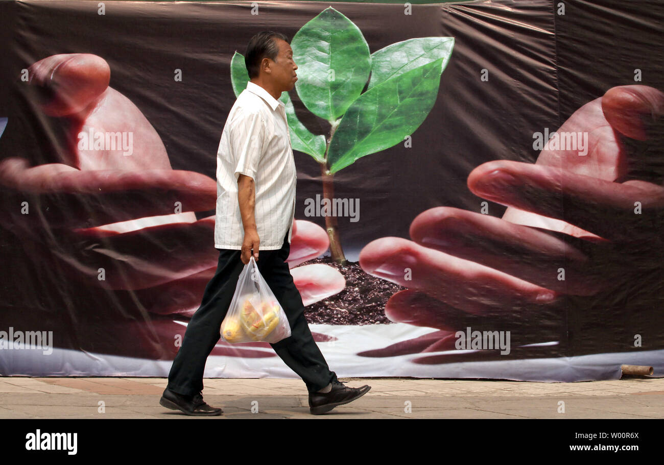 Un Chinois passe devant une affiche pour le développement d'énergie verte et renouvelable' au centre-ville de Beijing, le 25 juin 2010. L'énergie renouvelable est aider la Chine à achever sa transformation économique et permettre "la sécurité énergétique". UPI/Stephen Shaver Banque D'Images