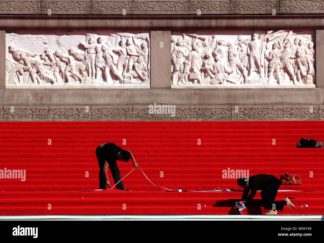 Les hommes chinois installer tapis rouge autour du monument de héros tombés sur la Place Tiananmen, un jour avant le 62e anniversaire de la fondation de la République populaire de Chine (RPC), à Beijing le 30 septembre 2011. La Chine marque le 62e anniversaire de la fondation de la RPC comme ils célébrer la Journée nationale le 1 octobre, avec des événements parrainés par le gouvernement ont eu lieu à travers le pays visant à renforcer le parti communiste. UPI/Stephen Shaver Banque D'Images