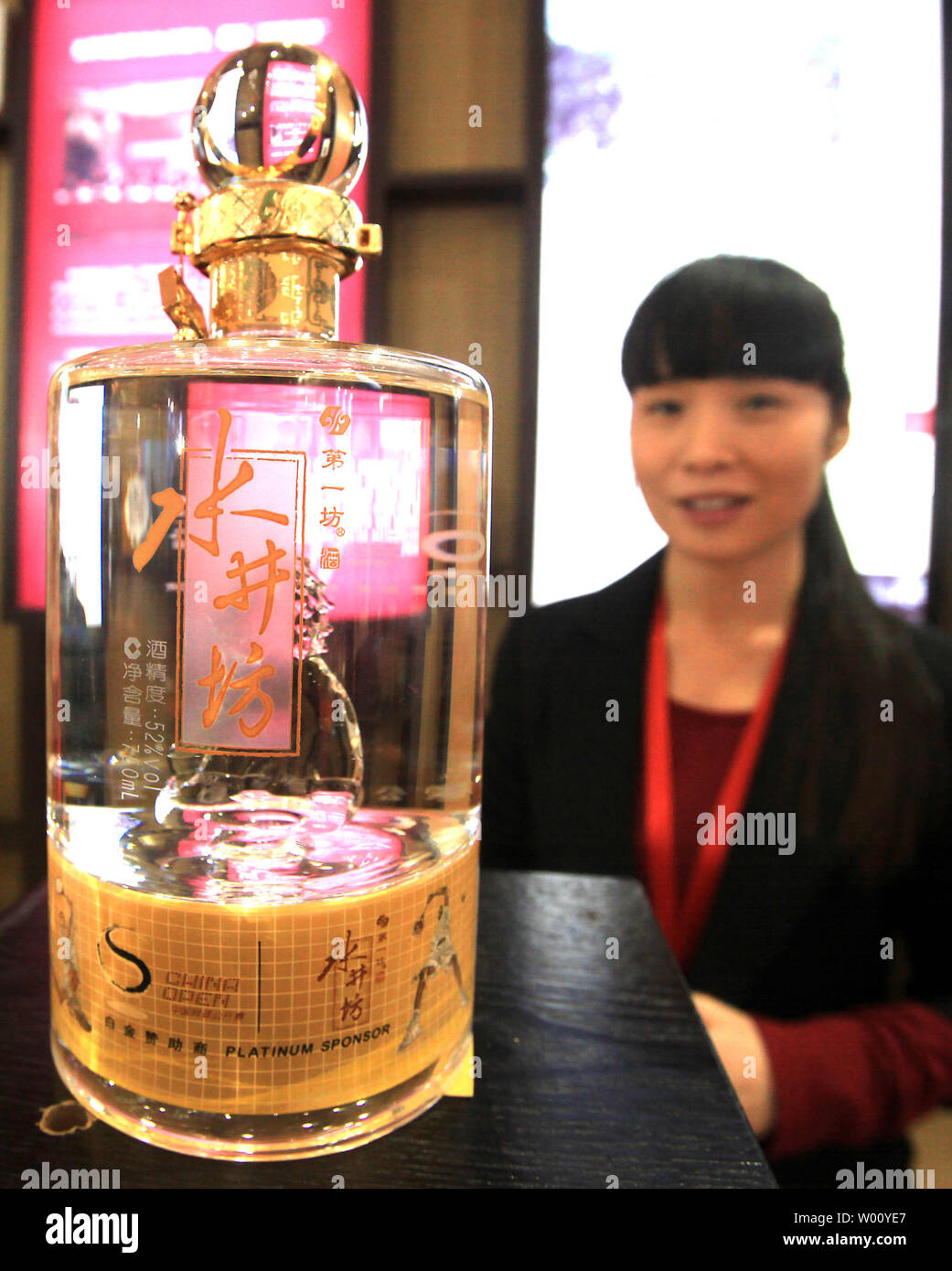 Une vendeuse chinoise assiste à son intérieur en vente au stand de haut, la preuve de l'alcool à une foire alimentaire à Beijing le 3 décembre 2011. Binge-drinking est de plus en plus courant pour les professionnels chinois, et souvent c'est même dans la description de poste. Les buveurs en Chine sont plus âgés et, dans de nombreux cas, comme le Japon, Taiwan et la Corée du Sud, de boire non pas seulement pour le plaisir mais des raisons de carrière. UPI/Stephen Shaver Banque D'Images