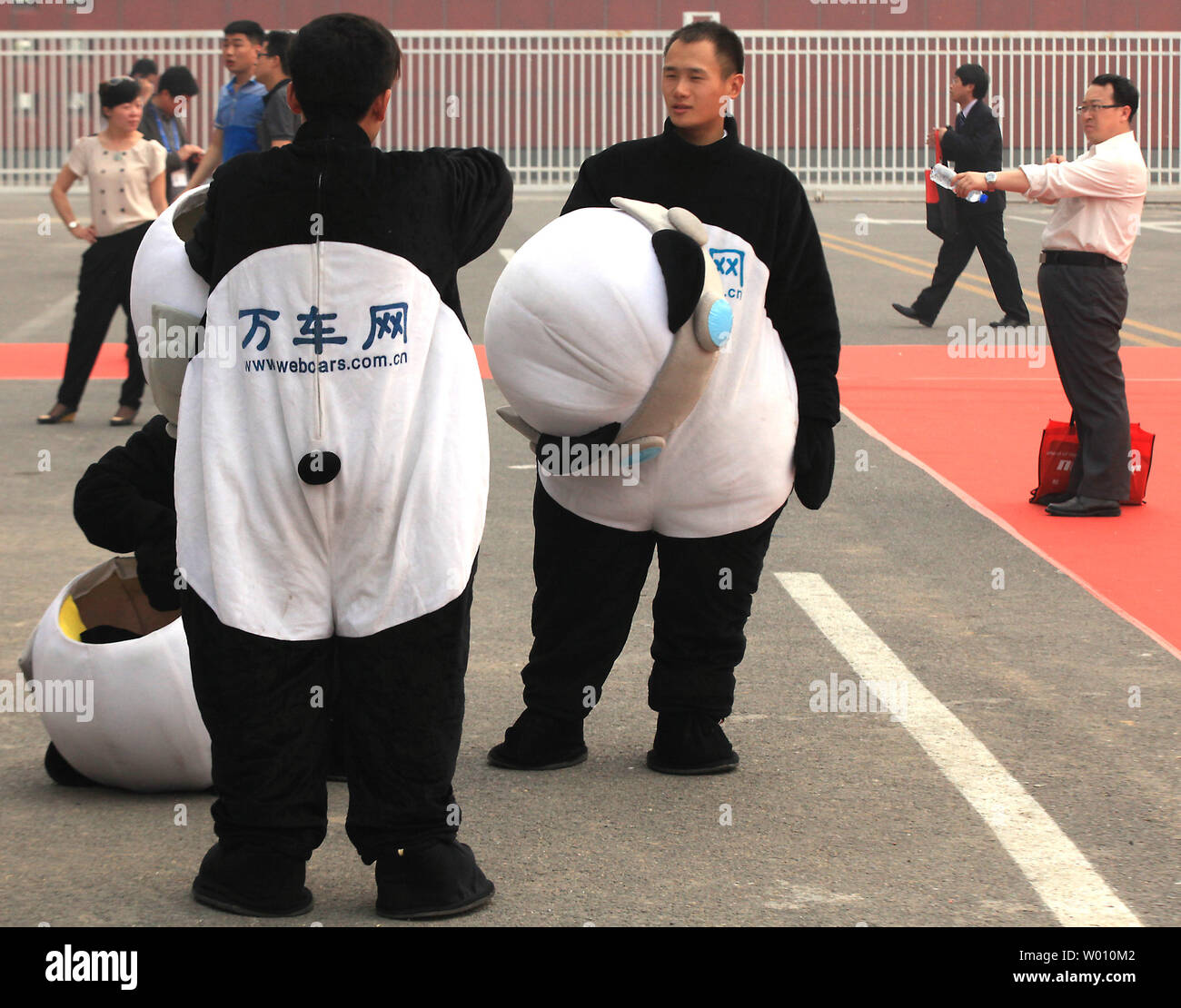 Les Chinois prennent une pause de travailler comme mascottes panda la promotion d'un site web à le plus grand show automobile, Auto China 2012, lors d'une journée d'ouverture montrent à Beijing le 23 avril 2012. La Chine est le plus grand marché de l'automobile, avec les constructeurs internationaux La mise en place de plantes massifs et de concessionnaires à travers le pays dans l'espoir de gagner une part du marché intérieur de plus en plus rapide. UPI/Stephen Shaver Banque D'Images