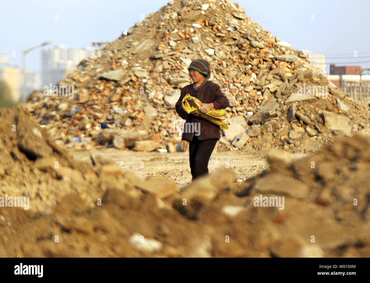 Une femme migrants chinois cherche les briques réutilisables et recyclables métaux sur un site de construction de logements démolis récemment à Beijing le 17 mai 2012. La Chine a maintenant la deuxième plus importante de l'économie, mais il a aussi 1,4 milliard de personnes, avec une estimation de 500 millions de personnes vivant dans une extrême pauvreté. Le produit intérieur brut par habitant est un peu plus de 4 000 $ par année, comparativement à environ 47 000 $ aux États-Unis. UPI/Stephen Shaver Banque D'Images