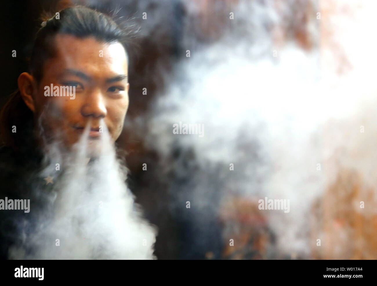 Un Chinois fume dans un restaurant à Beijing le 27 février 2015. La Chine, le plus grand consommateur et producteur de tabac, a été invité par l'Organisation mondiale de la Santé (OMS) d'utiliser des avertissements graphiques sur les paquets de cigarettes pour aider à combattre l'épidémie de tabagisme. La cigarette tue environ un million de chinois chaque année. Photo par Stephen Shaver/UPI Banque D'Images