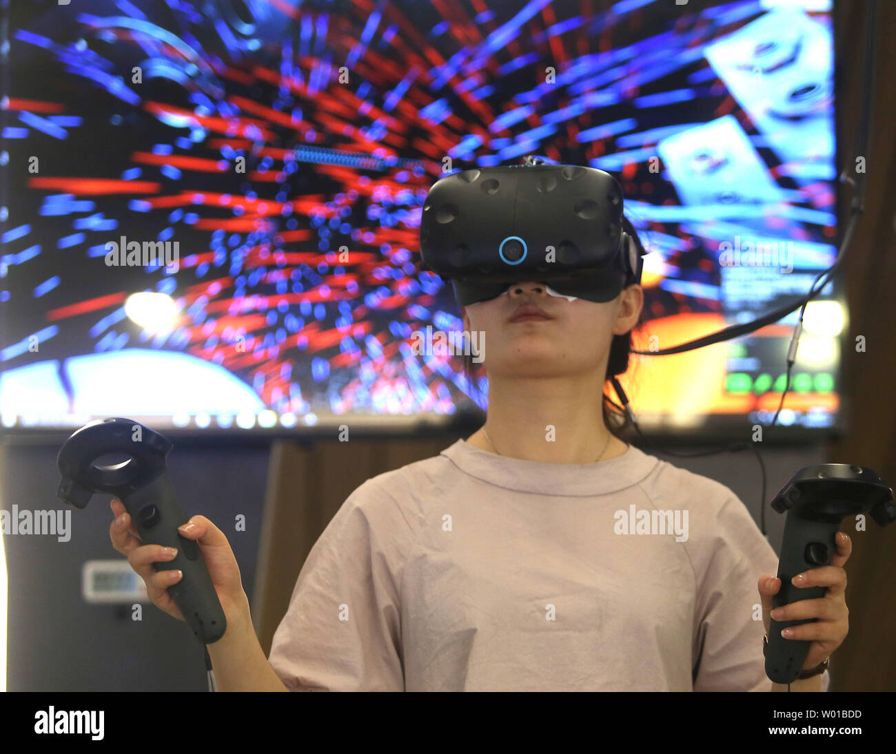 Une jeune chinoise joue un réalité virtuelle (RV) dans un jeu d'arcade VR à  Pékin le 25 août 2016. La Chine est un grand marché cible pour toutes les  choses, en particulier