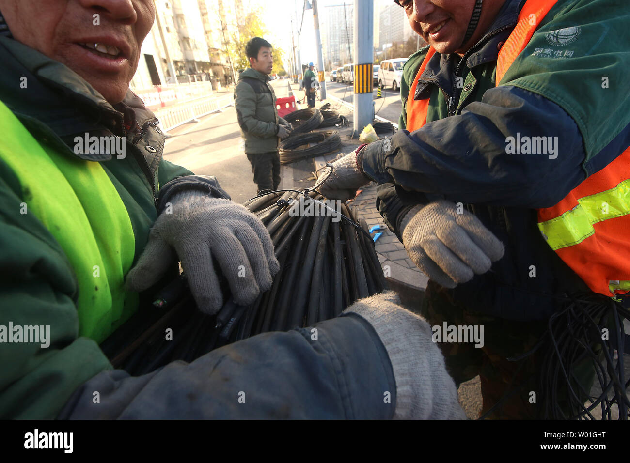 Les travailleurs chinois se détendre de grandes bobines de fils dans une rue de Beijing le 11 janvier 2019. Le gouvernement prévoit une croissance économique plus faible cible de 6-6.5  % en 2019 après 6,6 % prévu en 2018, ce qui serait la plus faible expansion depuis 1990, selon des sources politiques. Photo par Stephen Shaver/UPI Banque D'Images