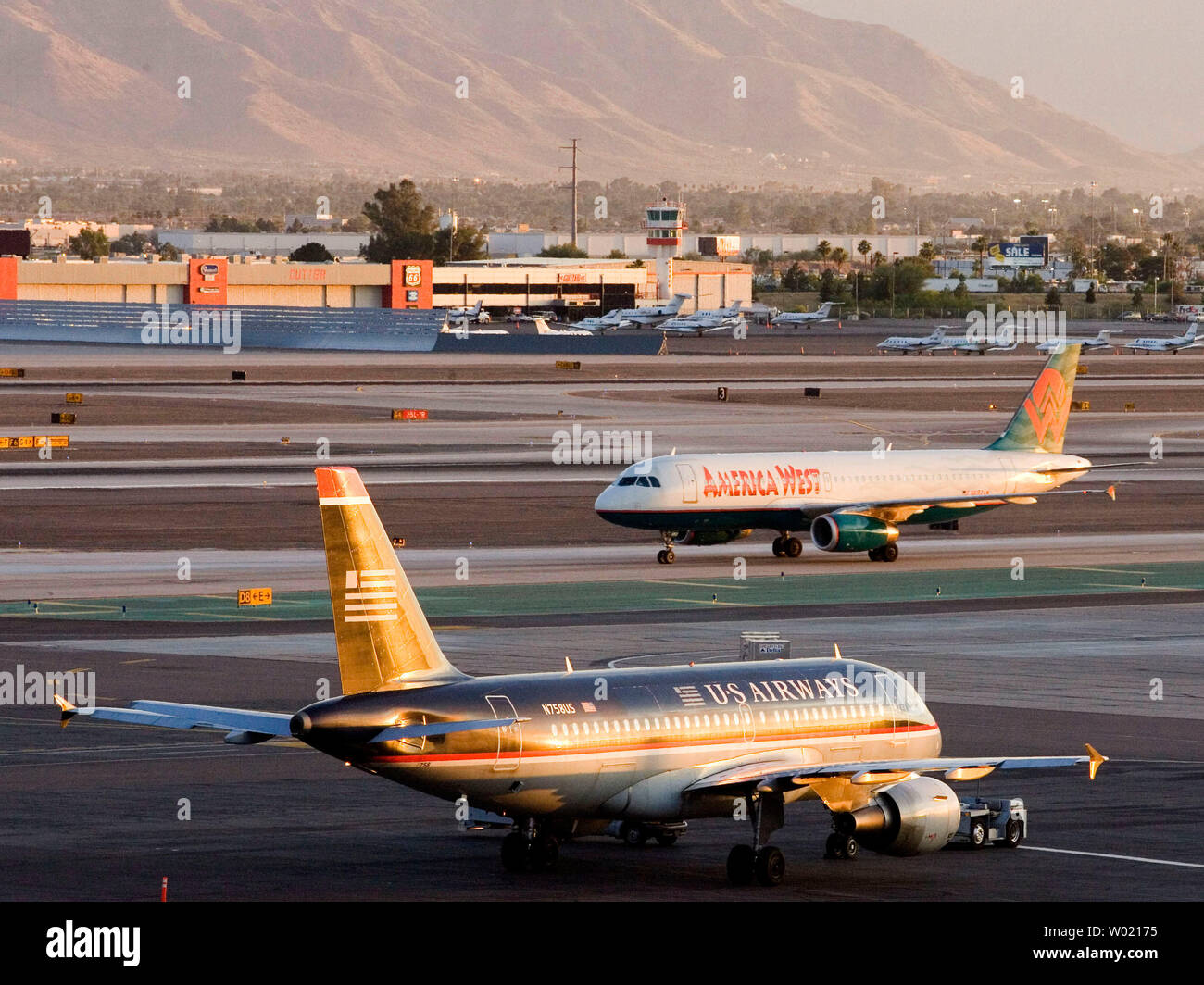 Avions d'America West Holdings Corporation et US Airways rencontrez sur le tarmac de l'aéroport international Sky Harbor de Phoenix, en Arizona, le 19 mai 2005. Les deux compagnies aériennes ont annoncé une fusion au siège de l'ouest de l'Amérique à Tempe, Arizona. (Photo d'UPI/Will Powers) Banque D'Images