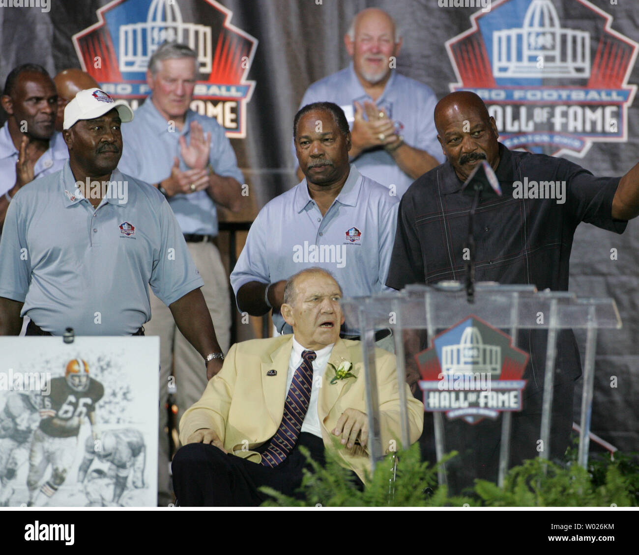 Passé Hall of Fame inductees Leroy Kelly (L), Bobby Mitchell (M), et Jim Brown (R) aide Cleveland Browns Gene Hickerson sur scène lors de la cérémonie de consécration 2007 au Pro Football Hall of Fame de Canton, Ohio, le 4 août 2007. (Photo d'UPI Stephen M.brut) Banque D'Images