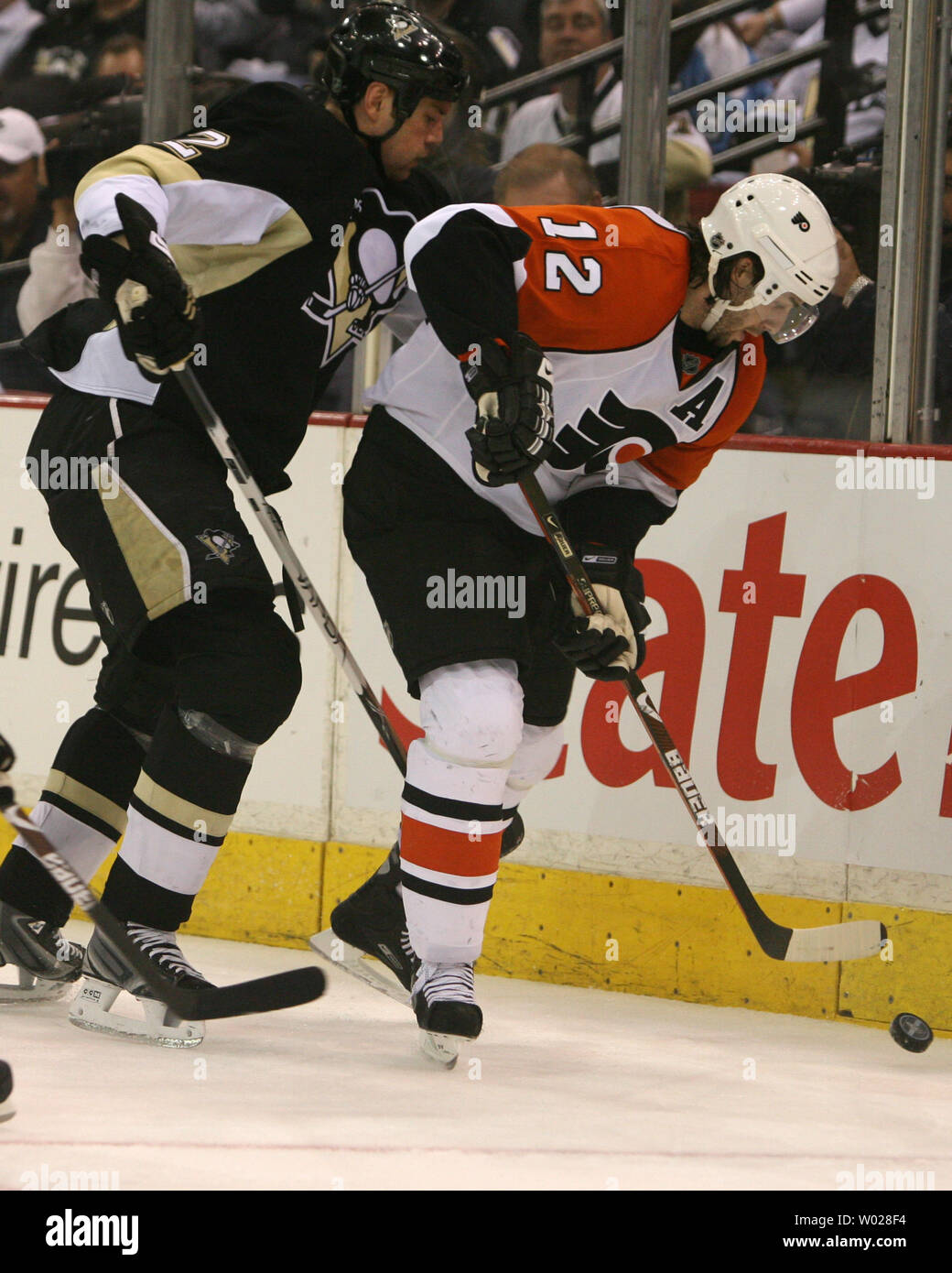 Les Flyers de Philadelphie Simon Gagné (12) vole le palet de Pittsburgh Penguins Hal Gill (2) dans la troisième période, de la première partie de la Conférence de l'Est 2009 Quaterfinals au Mellon Arena de Pittsburgh le 15 avril 2009. .(UPI Photo/Stephen brut) Banque D'Images