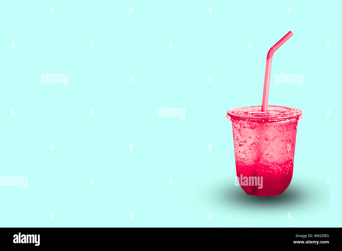 Jus de fruits rouges avec de la glace dans un verre en plastique avec chemin de détourage. Banque D'Images