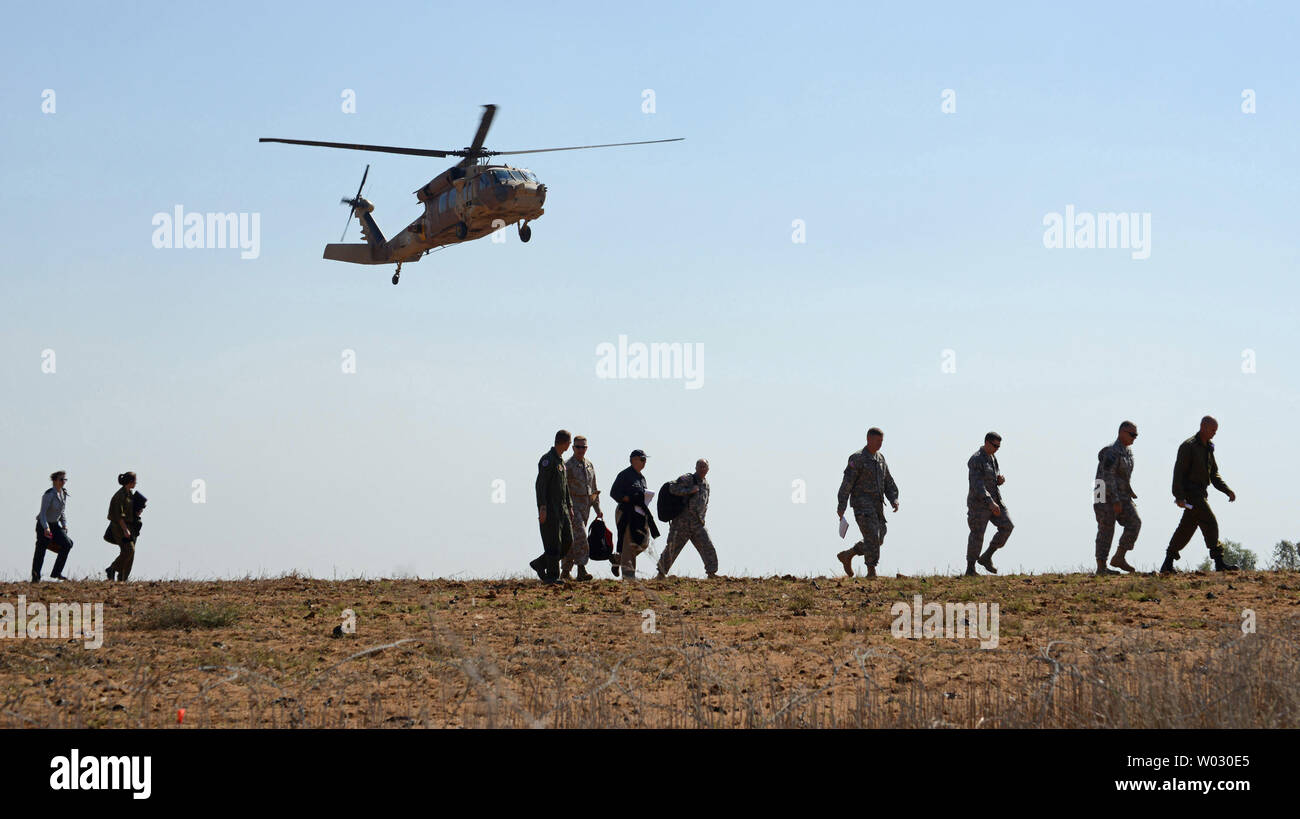 Du personnel militaire américain et israélien à pied sous un hélicoptère Black Hawk transportant le chef israélien de l'état-major général, le général Benny Gantz et United States Président des Chefs d'état-major général Martin Dempsey, lorsqu'ils arrivent pour une visite dans un centre de commande Iron Dome près du kibboutz Nitzanim, dans le sud d'Israël, le 30 octobre 2012. Le général Dempsey et le Lieutenant-général Benny Gantz a visité le centre de commande, au sein de la US-israélien d'un exercice de défense antimissile 12 Défi austère. UPI/Debbie Hill Banque D'Images