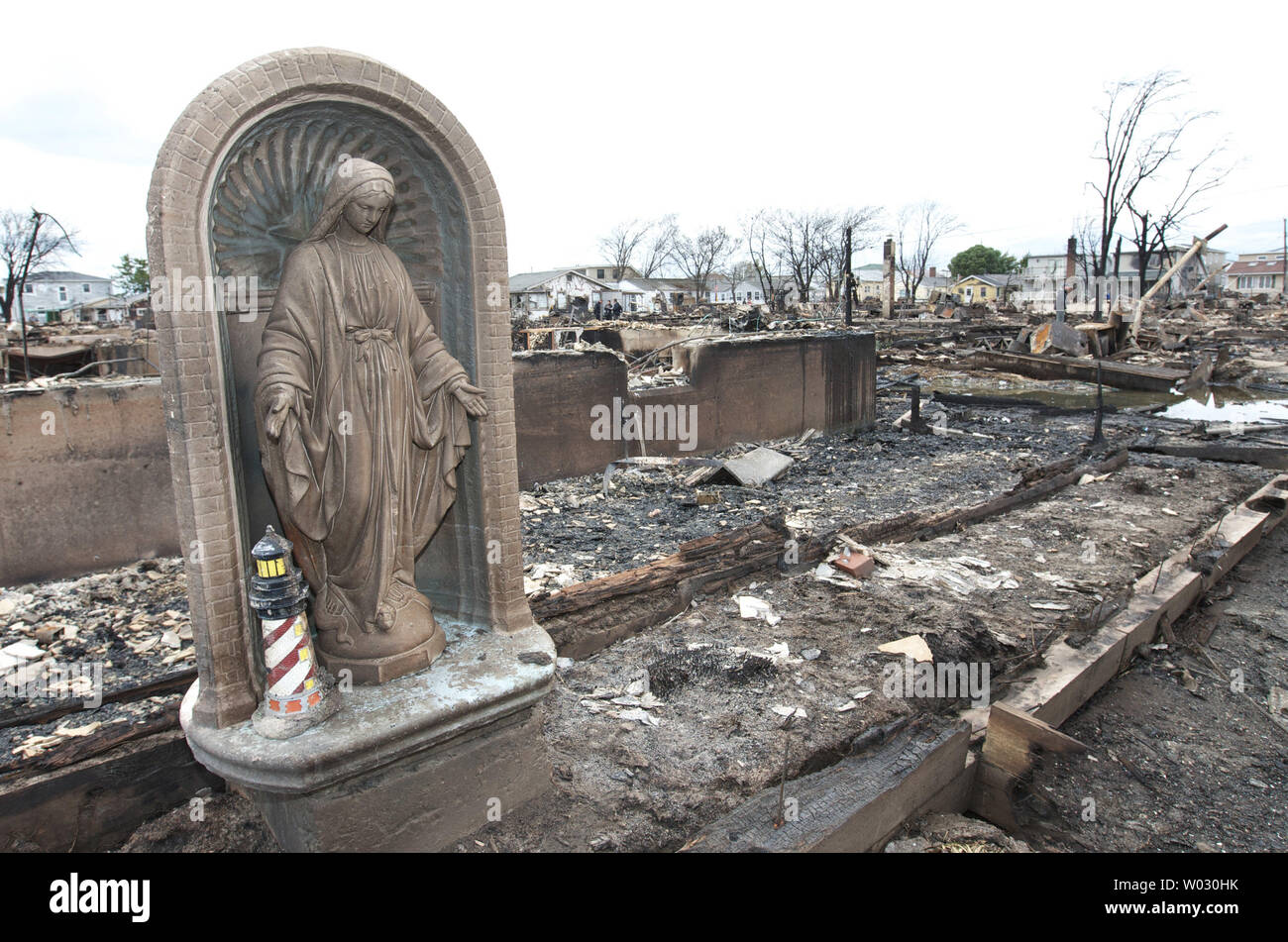 Une statue de la Vierge Marie est parmi les débris carbonisés où quatre-vingts maisons incendiées au sol dans la communauté de Breezy Point dans les quartiers de Queens le 31 octobre 2012 dans la ville de New York. Des vents violents provoqués par l'Ouragan Sandy, deux jours avant l'incendie alimenté alors que de l'eau élevé, il était difficile aux pompiers pour circonscrire le feu. UPI /Monika Graff Banque D'Images