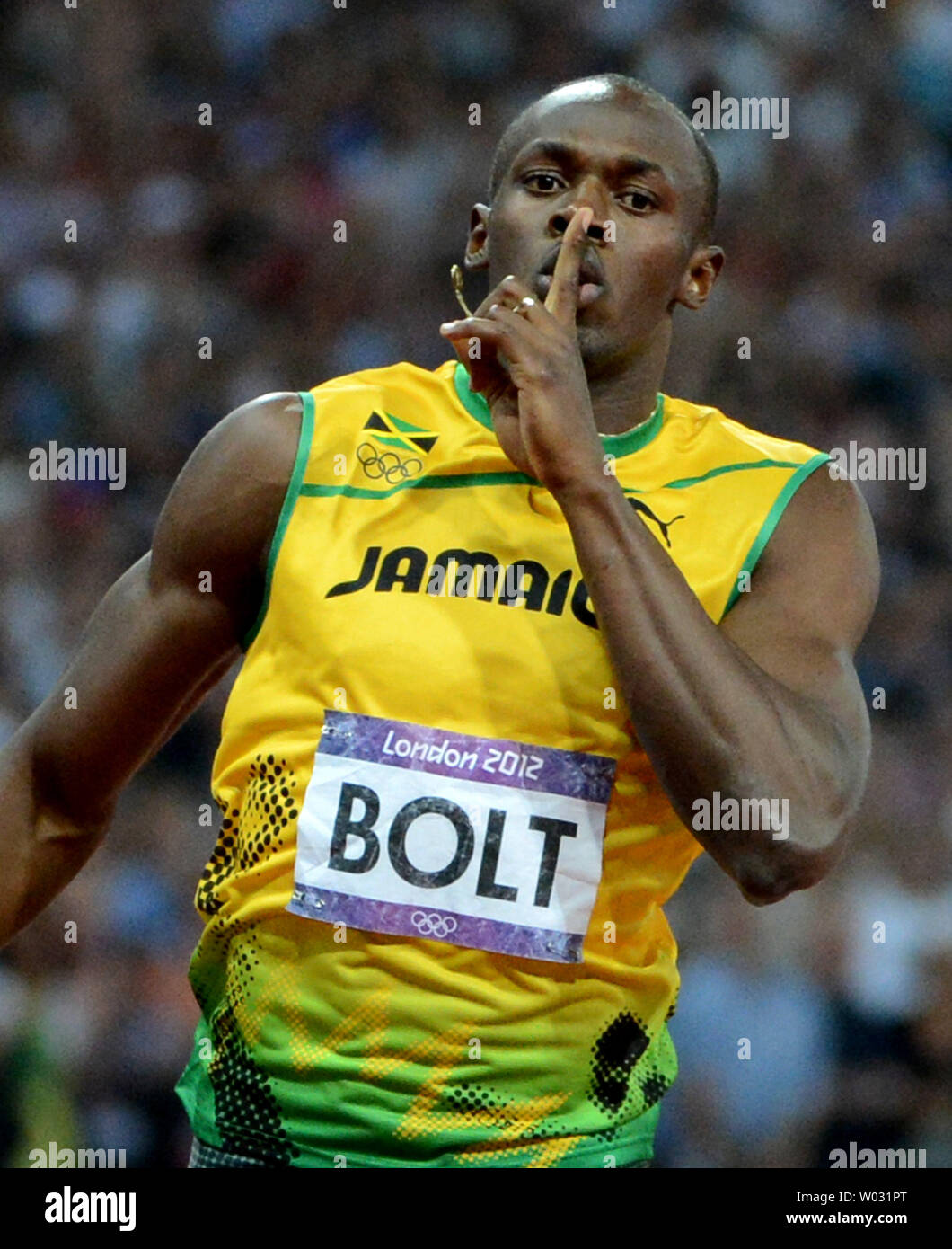 Usain Bolt de la Jamaïque des gestes aussi il passe la ligne d'arrivée pour gagner la médaille d'or chez les hommes finale 200M au Stade Olympique au cours de la London Jeux Olympiques d'été de 2012 dans le Parc olympique de Stratford, Londres, le 9 août 2012. Bolt est devenu le premier athlète olympique à remporter le 100M et 200M dans les Jeux olympiques consécutifs. Son temps était 19,32. La Jamaïque a balayé la course avec ses coéquipiers Yohan Blake obtenir l'argent et Warren Weir la médaille de bronze. UPI/Pat Benic Banque D'Images