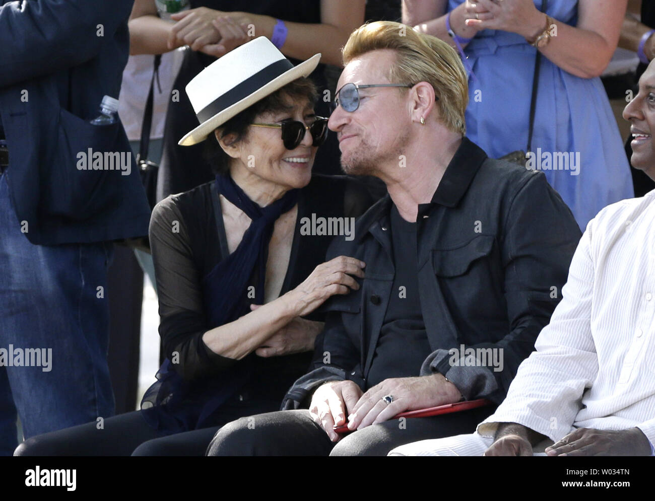 Bono de U2 et de Yoko Ono s'asseoir ensemble et d'écouter les haut-parleurs avant qu'ils dévoilent un géant 24' x 10' hommage à John Lennon en présence secrétaire générale d'Amnesty International Salil Shetty, à l'Ellis Island Musée National de l'Immigration à New York le 29 juillet 2015. La tapisserie a été commandée par l'art pour l'amnistie fondateur Bill Shipsey pour remercier Ono pour Amnesty International les droits d'enregistrer les versions de Lennon's post-chansons des Beatles en 2004, permettant à l'amnistie d'amasser plus de 5 millions de dollars en redevances depuis. Bono, The Edge et Jimmy impresario d'affaires de la musique Banque D'Images