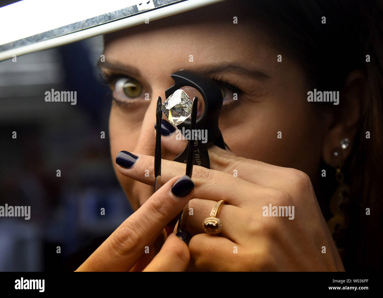 Un négociant de diamants diamond inspecte une pendant la Semaine internationale du diamant à l'Israel Diamond Exchange à Ramat Gan, près de Tel Aviv, Israël, le 16 février 2016. L'Israel Diamond Exchange est considérée comme la plus sûre au monde, couvrant 100 000 mètres carrés. Quatre cents acheteurs de partout dans le monde convergent sur 260 entreprises de fabrication et de commerce de diamants comme certains 1,5000 personnes sont attendues à plus de $1 milliards de dollars de diamants polis cette semaine. Israël les diamants sont vendus pour plus de 2 000 $ par carat et l'annuel 2015 l'exportation de diamants ont dépassé 7,1 milliards de dollars, comprenant Banque D'Images