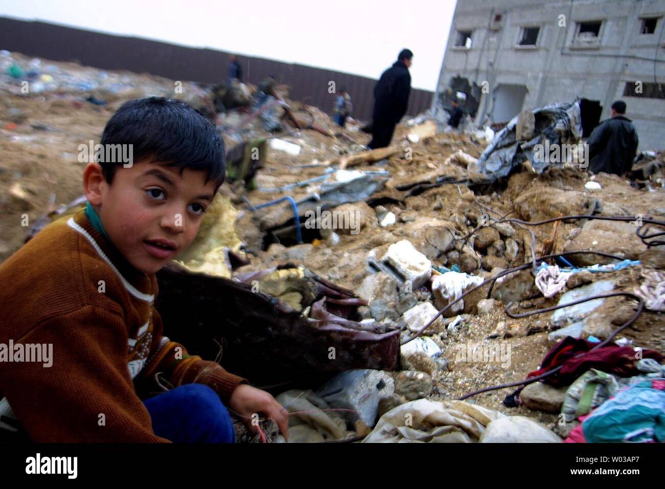 Un garçon palestinien est assis sur les décombres de sa maison, détruite par un bulldozer israélien près de la frontière avec l'Egypte dans le sud de Gaza camp de réfugiés de Rafah, le 23 janvier 2004. Des centaines de Palestiniens ont perdu leur maison suite à une opération militaire israélienne au cours des trois derniers jours. (Photo/UPI Mohamad Ismail) Banque D'Images