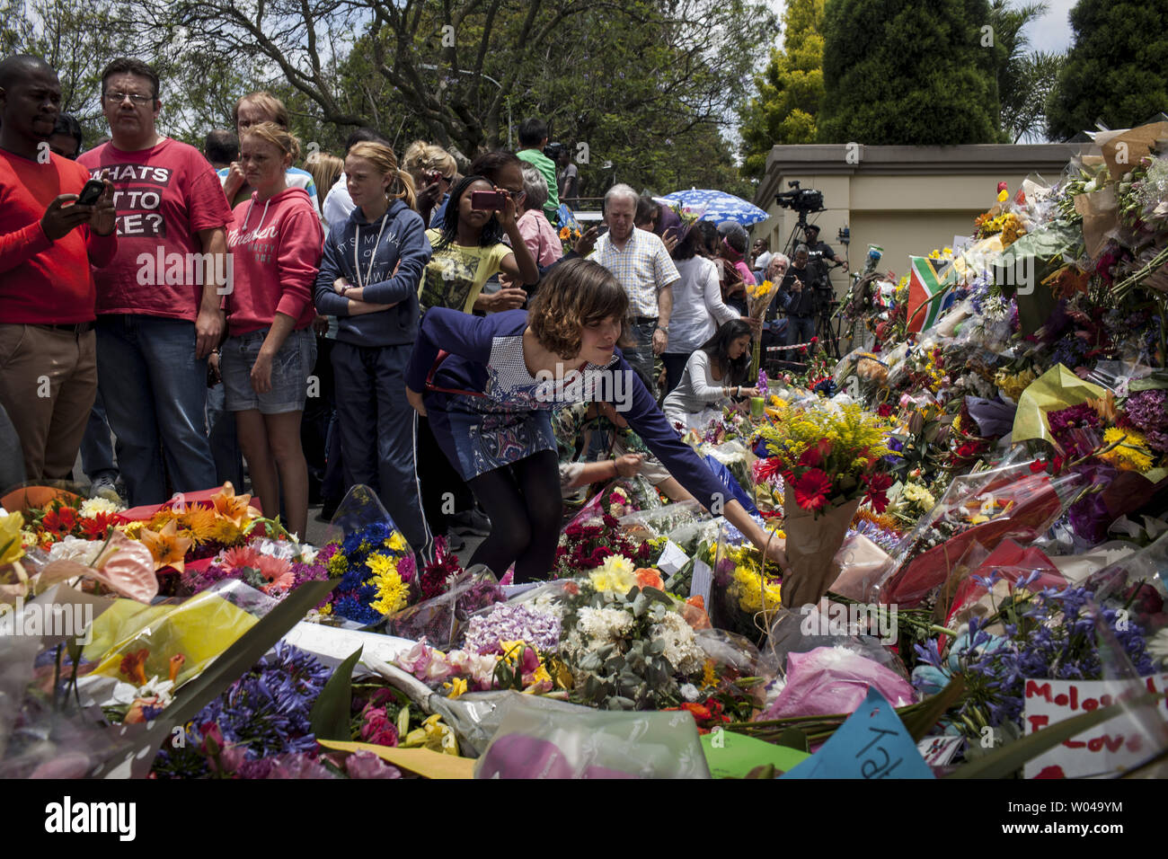 Les foules sont venues de l'ancienne maison de Nelson Mandela dans la banlieue de Johannesburg Houghton pour rendre hommage et célébrer sa vie, Afrique du Sud, le 7 décembre 2013. Mandela, l'ancien président sud-africain et icône de la lutte anti-apartheid, est décédé le 5 décembre 2001, à l'âge de 95 ans après les complications d'une infection pulmonaire récurrente. UPI/Charlie Shoemaker Banque D'Images