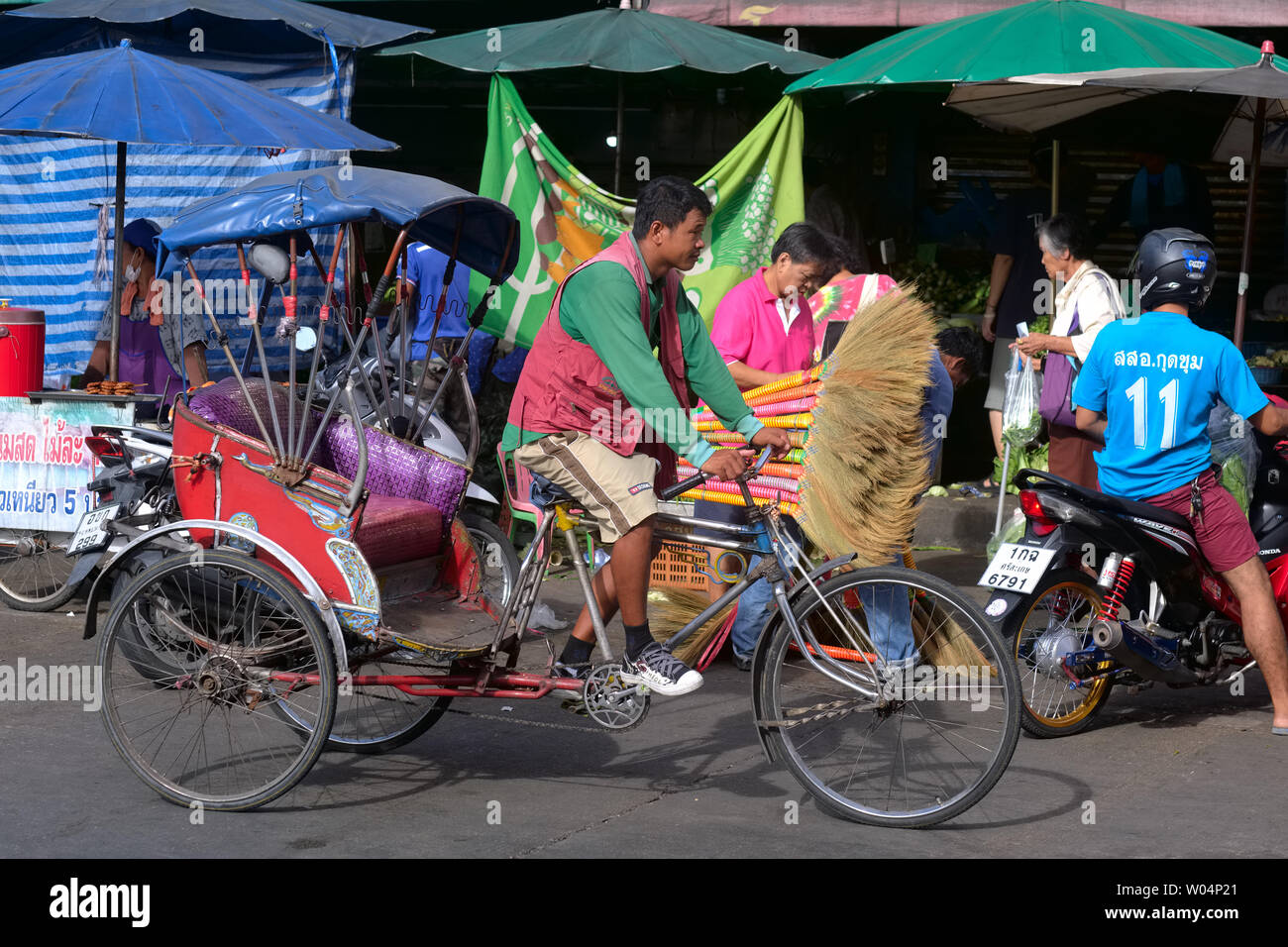 Un chauffeur avec un des quelques samlor ou trois roues vélos-pousse en Thaïlande, dans un marché à Nonthaburi près de Bangkok Banque D'Images