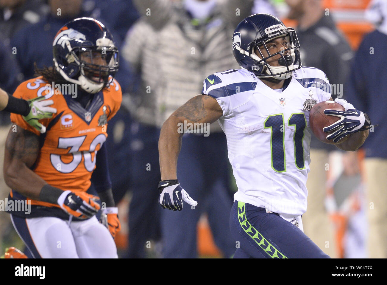 Seattle Seahawks le receveur Percy Harvin (11) exécute l'ouverture coup d'envoi de la deuxième moitié de 87 verges de sécurité solide comme David Bruton (30) à leur poursuite le Super Bowl XLVIII à MetLife Stadium à East Rutherford, New Jersey le 2 février 2014. Stade MetLife héberge la première piscine de la NFL Super Bowl par temps froid. UPI/Riche Kane Banque D'Images Seattle Seahawks le receveur Percy Harvin (11) exécute l'ouverture coup d'envoi de la deuxième moitié de 87 verges de sécurité solide comme David Bruton (30) à leur poursuite le Super Bowl XLVIII à MetLife Stadium à East Rutherford, New Jersey le 2 février 2014. Stade MetLife héberge la première piscine de la NFL Super Bowl par temps froid. UPI/Riche Kane Banque D'Images