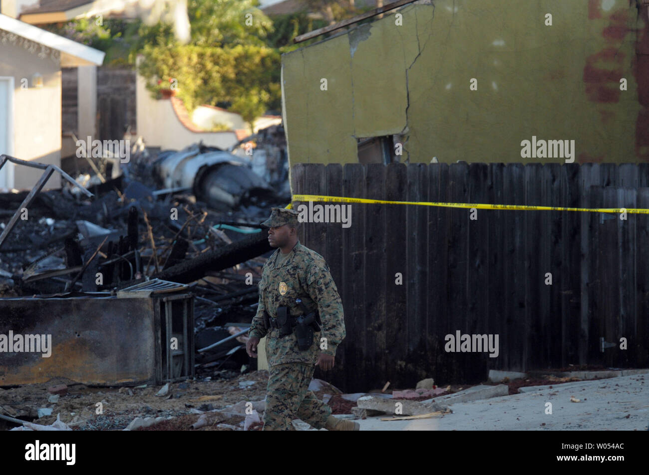 Un officier de la Police militaire du Corps des marines passe devant des débris sur le 9 décembre 2008 sur le site de l'écrasement d'un Marine Corps F/A-18D Hornet patrouille qui s'est écrasé dans un quartier de San Diego, le 8 décembre 2008, tuant deux adultes et deux enfants. Le pilote s'éjecter après avoir essayé d'orienter le jet sinistrées dans un canyon à proximité. (Photo d'UPI/Earl S. Cryer) Banque D'Images