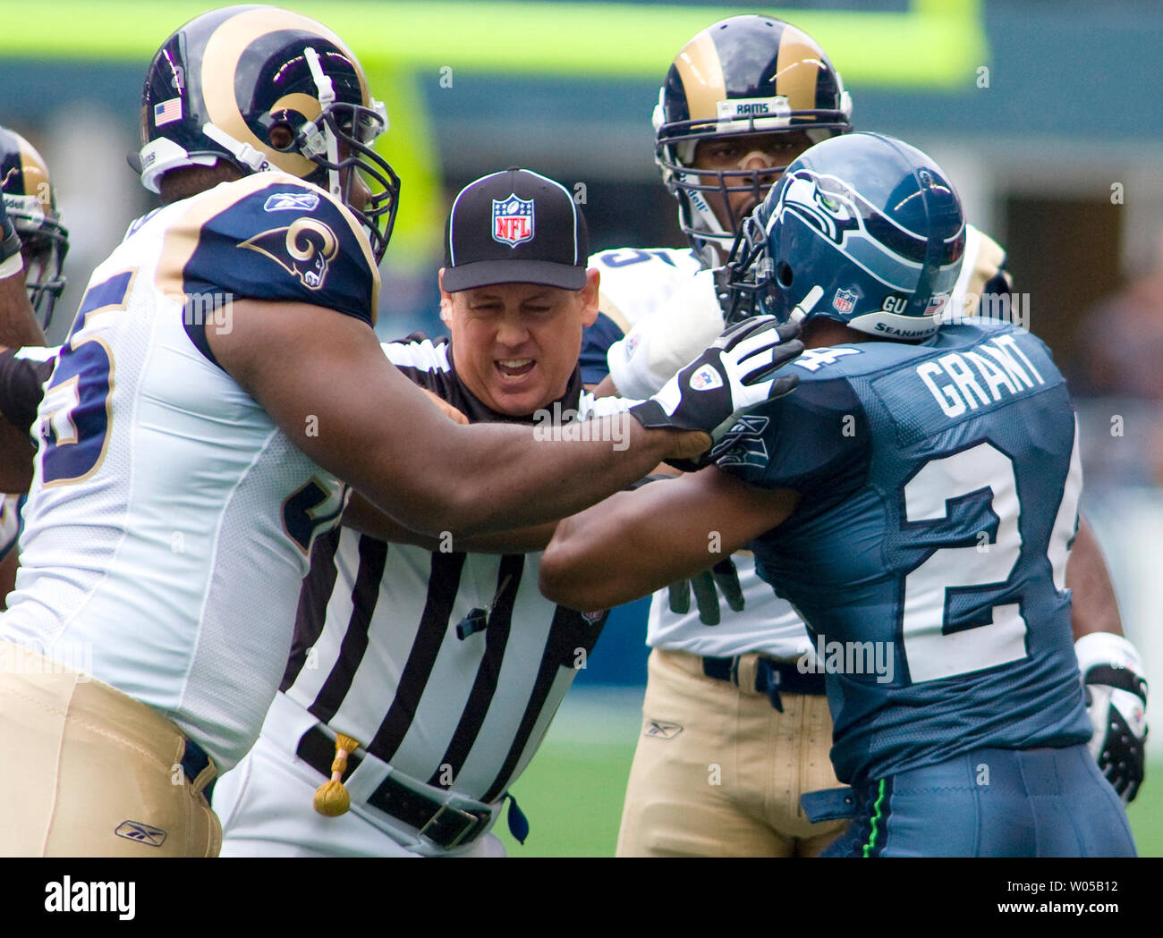 Juge de ligne (C) Jeff Seeman rompt une lutte entre Saint Louis Rams' Clifton Ryan (L) et Seattle Seahawks' Deon Grant (R) dans le deuxième trimestre à Qwest Field à Seattle le 21 septembre 2008. Les Seahawks a battu les Rams 37-13. (Photo d'UPI/Jim Bryant) Banque D'Images