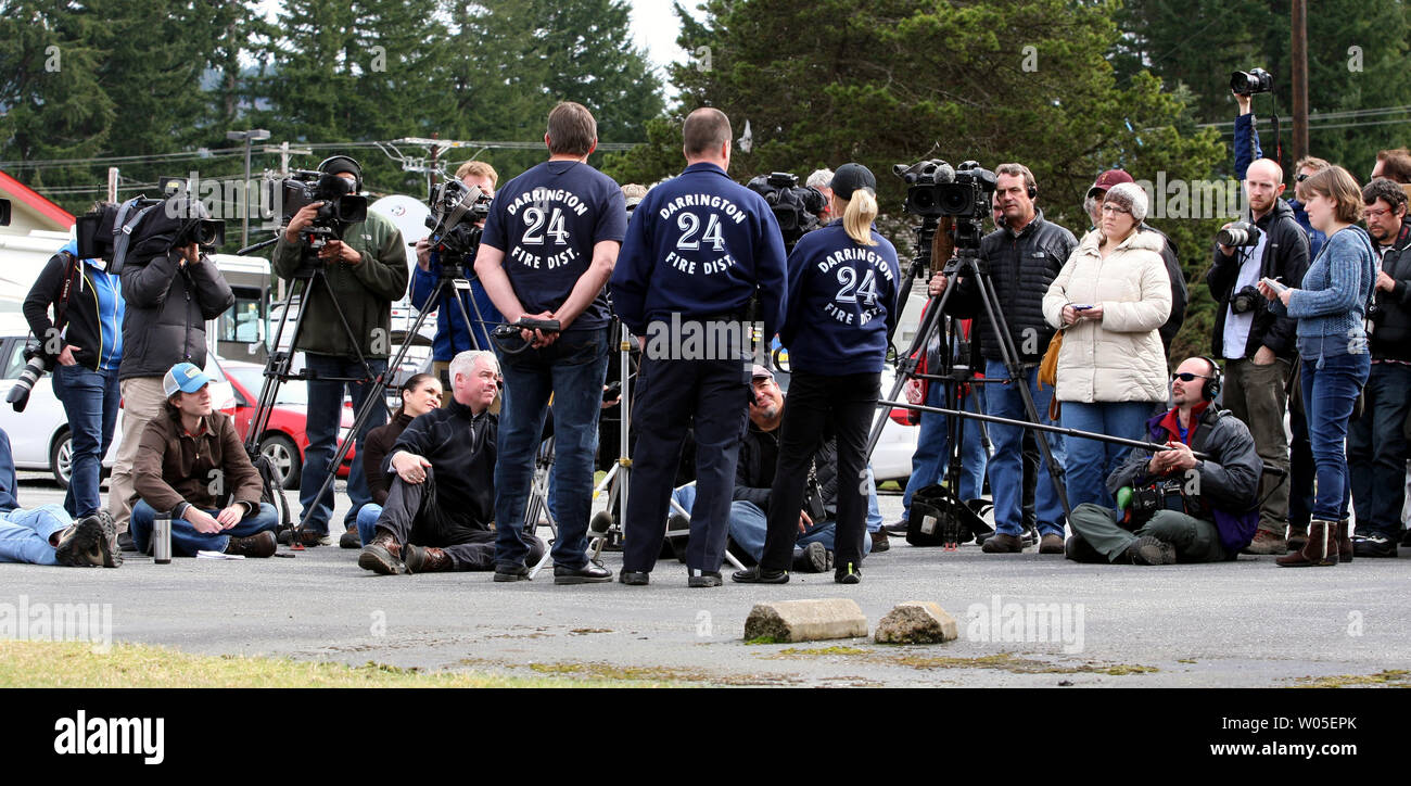 Les membres des médias interview Jeff McClelland, gauche, Eric Finzimer, moyenne et Jan McCelland, de Darrington Fire Department 24 comme ils décrivent leur expérience comme étant l'un des premiers intervenants sur les lieux d'une coulée de samedi qui a enseveli la ville de Oso, à environ 12 milles à l'ouest de Darrington, Washington le 26 mars 2014. Plus de 200 membres du personnel de recherche et de sauvetage continuent de chercher des survivants ou des organismes dans l'aggravation des conditions météorologiques. Quelque 25 corps ont été découverts avec plus de 90 manquant dans la coulée de tragique. UPI/Jim Bryant Banque D'Images