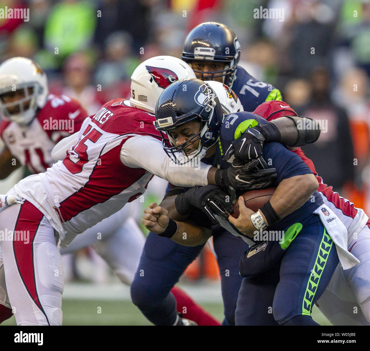 Seattle Seahawks quarterback Russell Wilson (3) est renvoyé pour une perte de quatre verges par Arizona Cardinals défensive fin Chandler Jones (55) attaquer défensive Corey Peters (98) au cours du quatrième trimestre à CenturyLink Field le 30 décembre 2018 à Seattle, Washington. Seattle Seahawks battre les cardinaux 27-24. Photos par Jim Bryant/UPI Banque D'Images