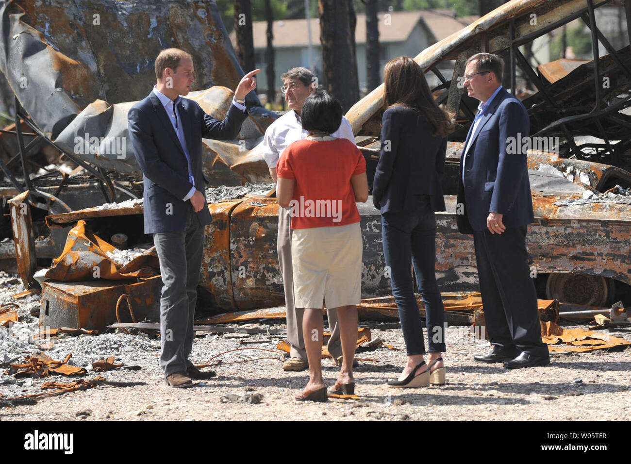 Pillay-Kinee maire Karina (pull rouge) escorts le Prince William et son épouse Kate, le duc et la duchesse de Cambridge, dans une promenade par un feu de forêt, quartier dévasté durant leur visite impromptue à Slave Lake, Pillay-Kinee du nord de la petite communauté de l'Alberta, le 6 juillet 2011. UPI/hr/avec la permission de Patrimoine Canada Banque D'Images