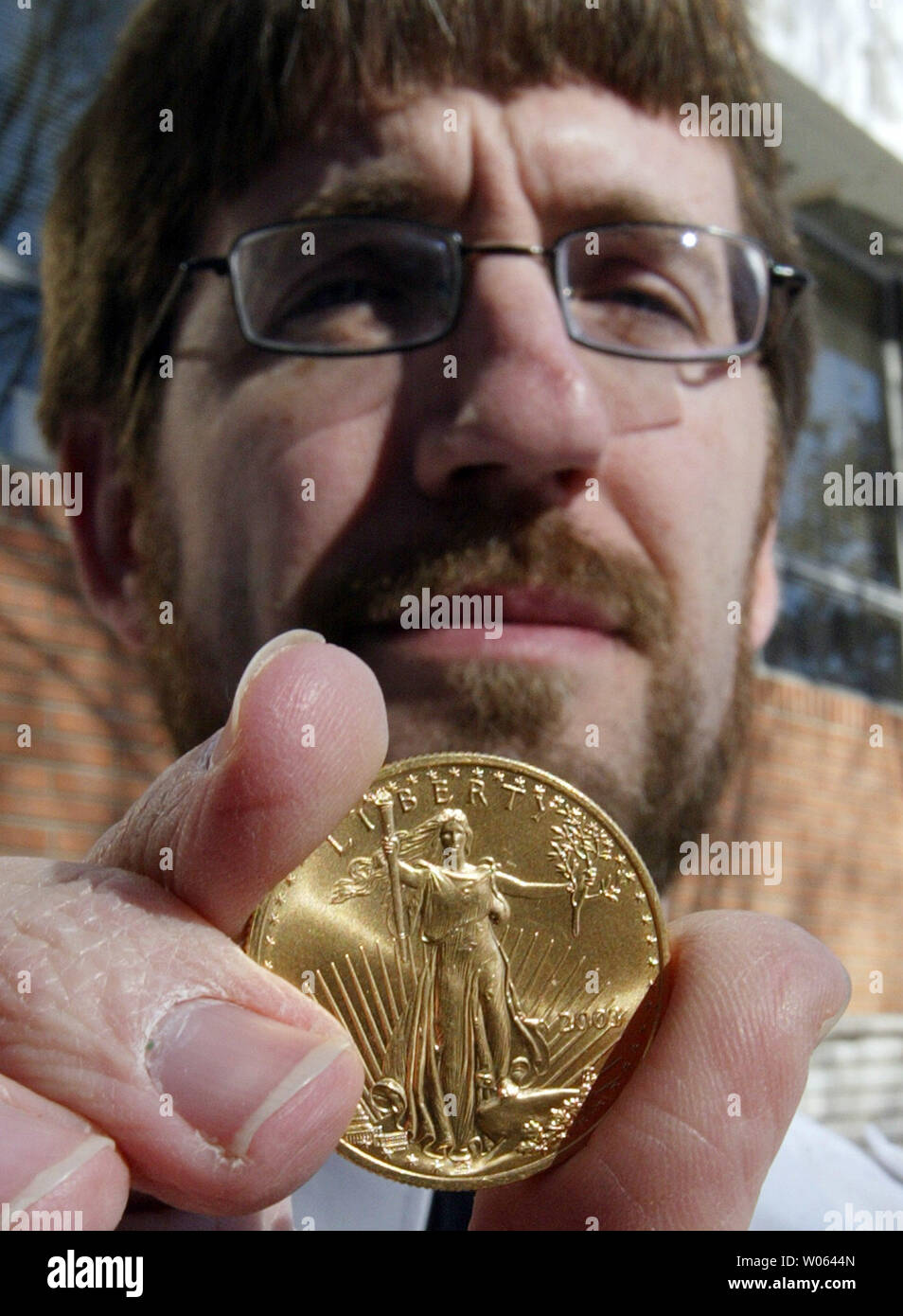 Le capitaine de l'Armée du Salut Brian Davis affiche la première monnaie d'or récupéré de ses bouilloires rouges cette saison de vacances à St Louis le 9 décembre 2005. Une liberté d'or a été trouvé dans une pièce électrique rouge, lâché par un döner anonyme en mémoire de son épouse Annie. Le donneur laisse une pièce d'or chaque saison de vacances, enveloppé dans une bande jaune avec le nom Annie écrit dessus. La pièce sera encaissé, aidant l'Armée du Salut de Saint-louis face à ses 4,5 million d'arbres de lumières objectif. (Photo d'UPI/Bill Greenblatt) Banque D'Images