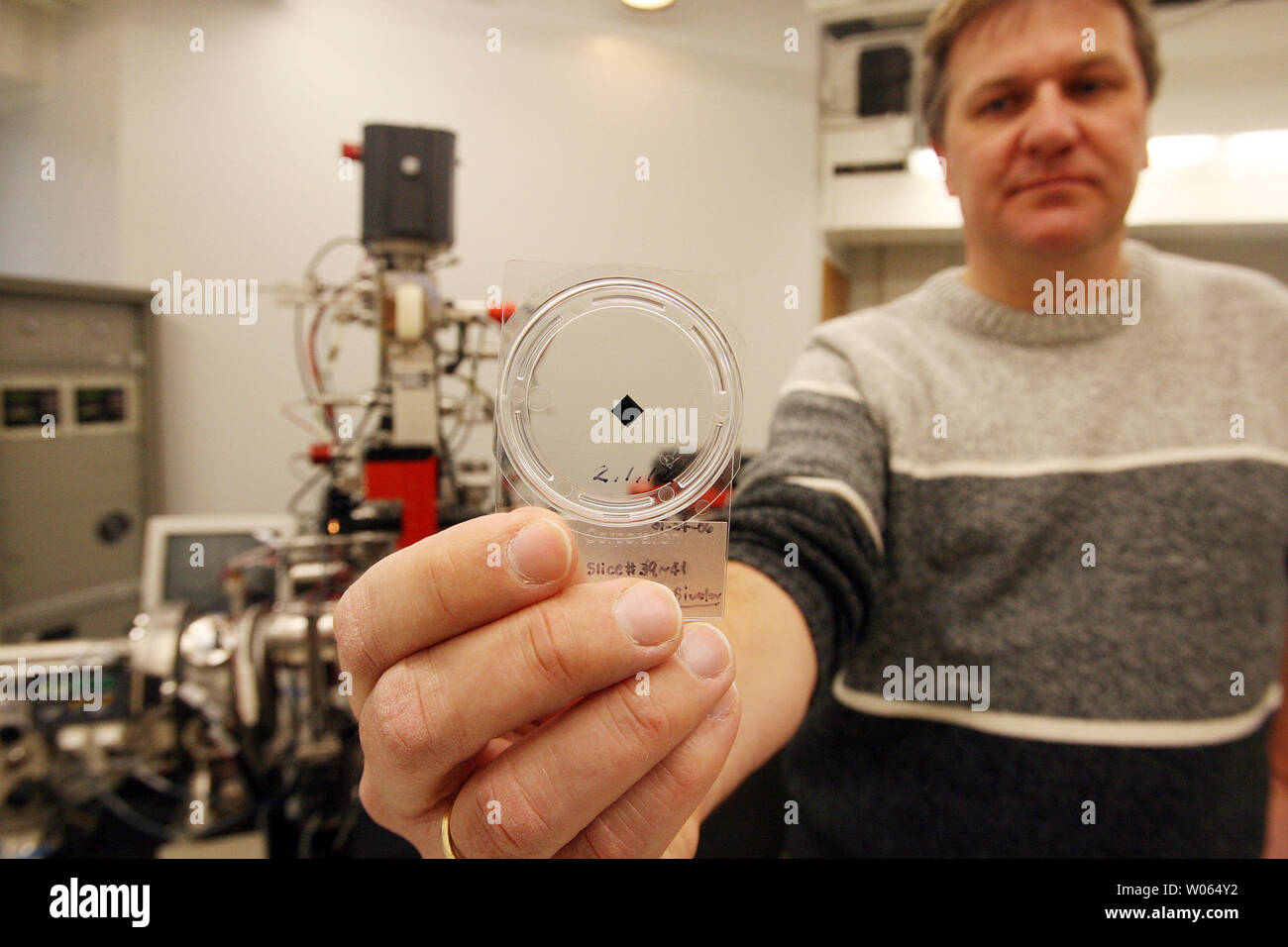 Frank Stadermann, Ph.D, directeur de recherche au Département de physique à l'Université Washington affiche un récipient avec trois tranches d'une particule de poussière cométaire recueillies pendant sept ans de la NASA 2,88 milliards de km de la mission Stardust aller-retour pour recueillir des particules de poussière interstellaire et cométaire, à St Louis le 9 février 2006. Stadermann, qui est un conseiller sur la mission Stardust, est allé au Centre spatial Johnson de la NASA à Houston pour assister à l'ouverture le 17 janvier de l'échantillon récupéré Stardust qui a atterri canister 15 janvier dans l'Utah. L'échantillon a tenu un canister bac que capturé pa Banque D'Images