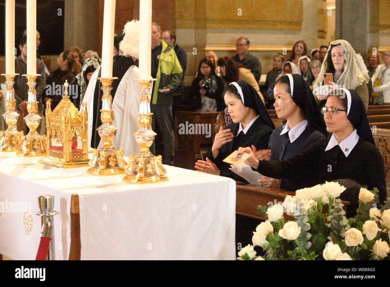 Les nonnes s'agenouiller pour prier devant le coeur d'un prêtre l'affichage à la Cathédrale Basilique de Saint Louis à Saint Louis le 15 mars 2019. Saint Jean Marie Vianney's incorrupt est considérée comme un grand cœur, relique de première classe. Le cœur du saint a résisté pendant plus de 150 ans. Une relique comme le cœur incorrupt propose un souvenir tangible de la communion avec les saints hommes et femmes qui sont passés avant, offrant une force de suivre leur exemple de vie fidèle. Saint Jean Marie Vianney, populairement connu comme le remède ? De l'Ars, est considéré comme un modèle de générosité, de pureté et de prière. Né en France Banque D'Images