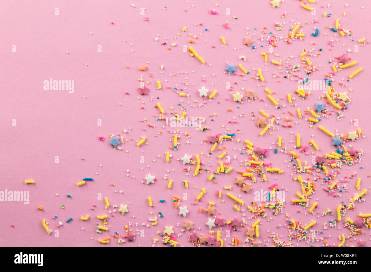 Saupoudre sur fond rose - assortiment de gâteaux colorés topping nutrifer pulvérisé sur fond rose sur coin avec espace pour texte - Vue de dessus de l'étoile Banque D'Images