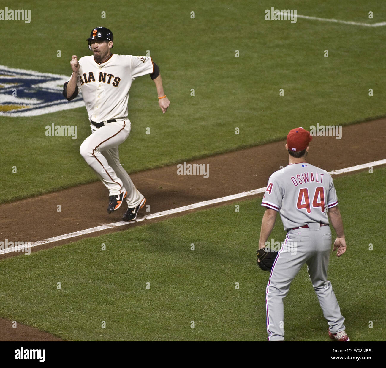 Giants de San Francisco Aubrey Huff fonce vers la plaque en bas de neuvième manche comme Philadelphia Phillies Roy Oswalt lanceur perdant ressemble à la balle en jeu dans le champ gauche quatre des CLN à AT&T Park à San Francisco Park le 20 octobre 2010. Juan Uribe a frappé un sacrifice à gauche qui ont obtenu à partir de la troisième. Huff Giants a gagné 6-5. UPI/Terry Schmitt Banque D'Images