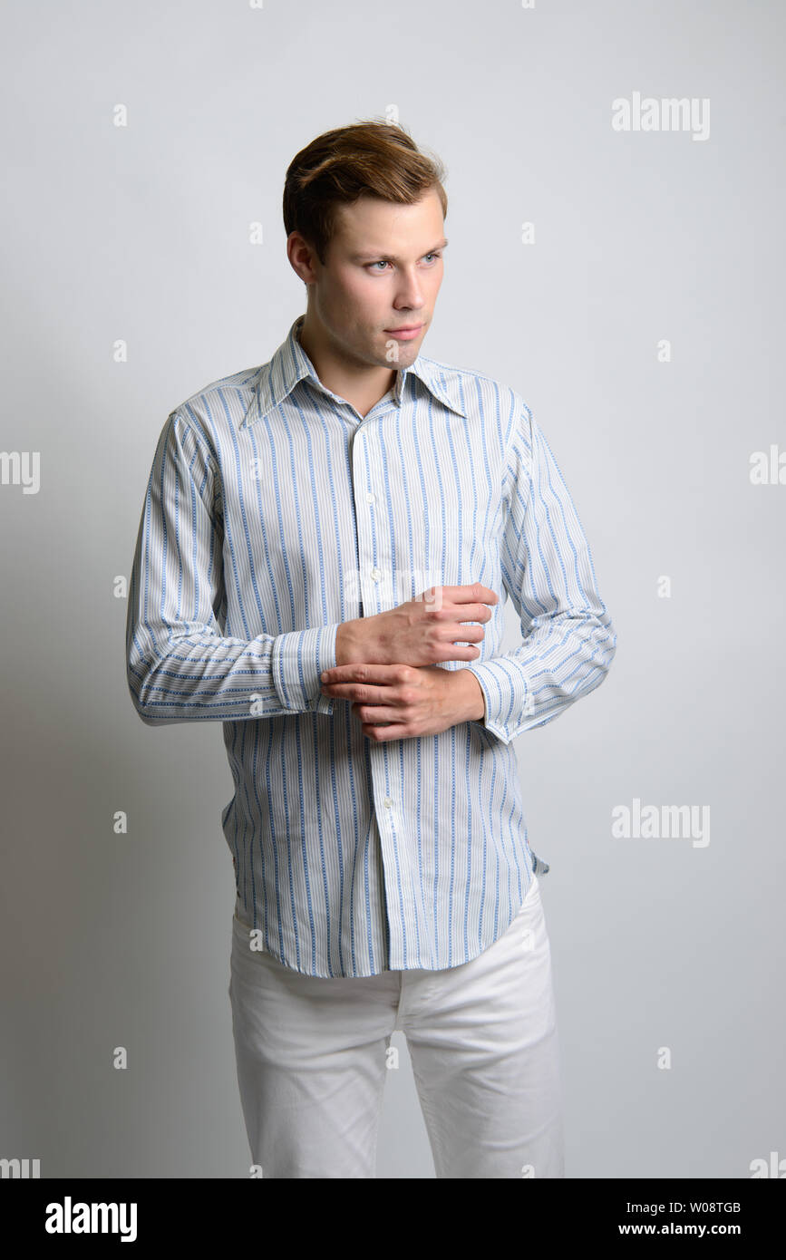 Un mannequin caucasien à cheveux bruns pose dans une chemise à rayures  vintage, un éditorial de mode vintage pour hommes Photo Stock - Alamy