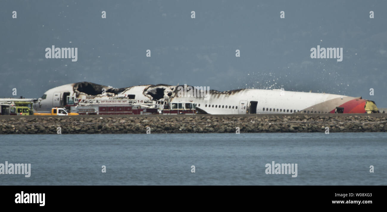 Les véhicules d'urgence entourent les vestiges d'un Boeing 777 d'Air Asiana sur la piste de l'Aéroport International de San Francisco après qu'il s'est écrasé à l'atterrissage à San Francisco le 6 juillet 2013. L'avion était en provenance de Séoul. UPI/Terry Schmitt Banque D'Images