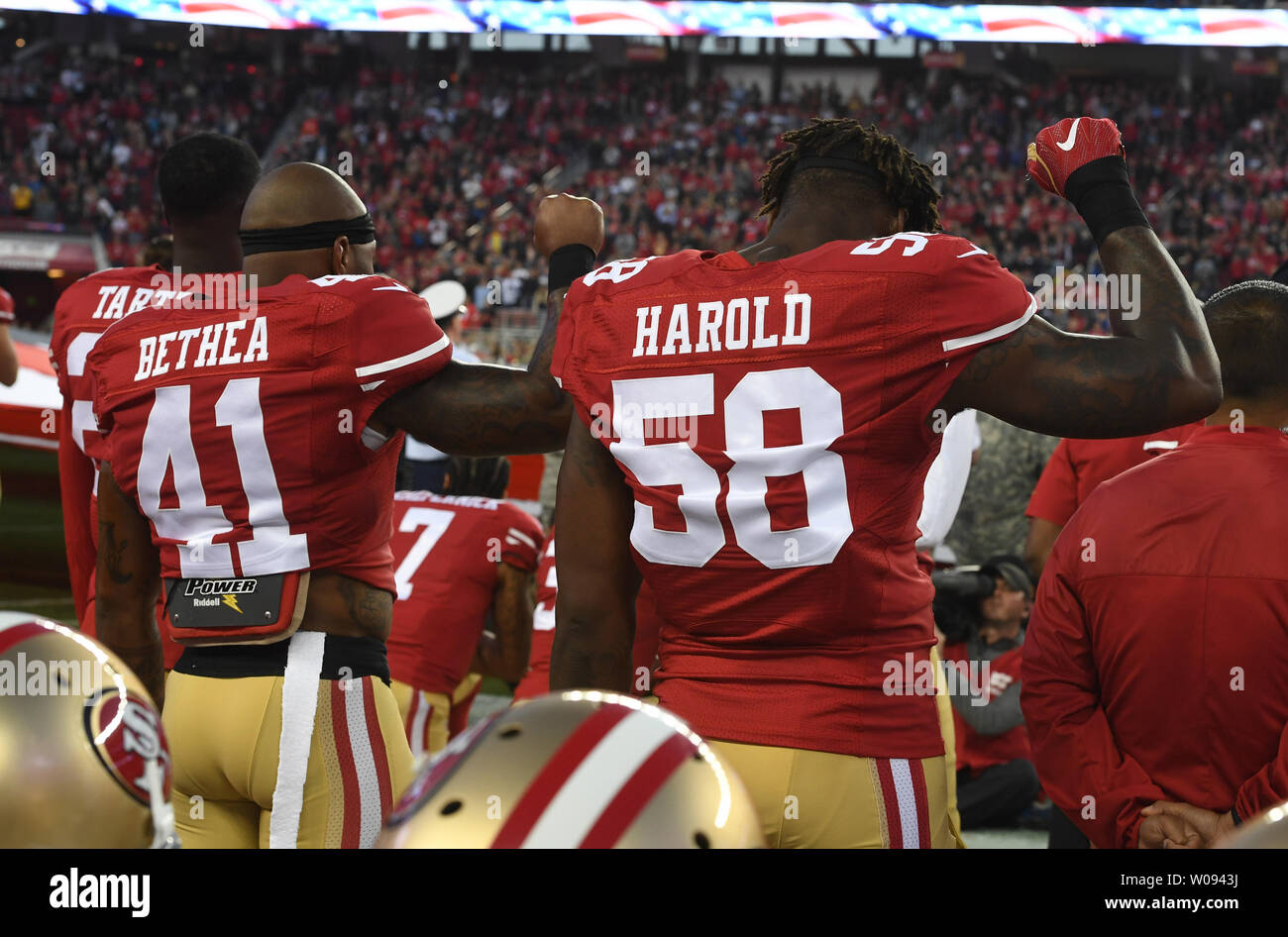 San Francisco 49ers Antoine Bethea (41) et Eli Harold (58) hold up les poings serrés comme QB Colin Kaepernick (7) s'agenouille pendant l'hymne national avant de jouer les Los Angeles Rams chez Levi's Stadium à Santa Clara (Californie) le 12 septembre. 2016. Kaepernick a commencé pendant l'hymne national des protestations contre l'injustice raciale qui se multiplient. Photo par Terry Schmitt/UPI Banque D'Images