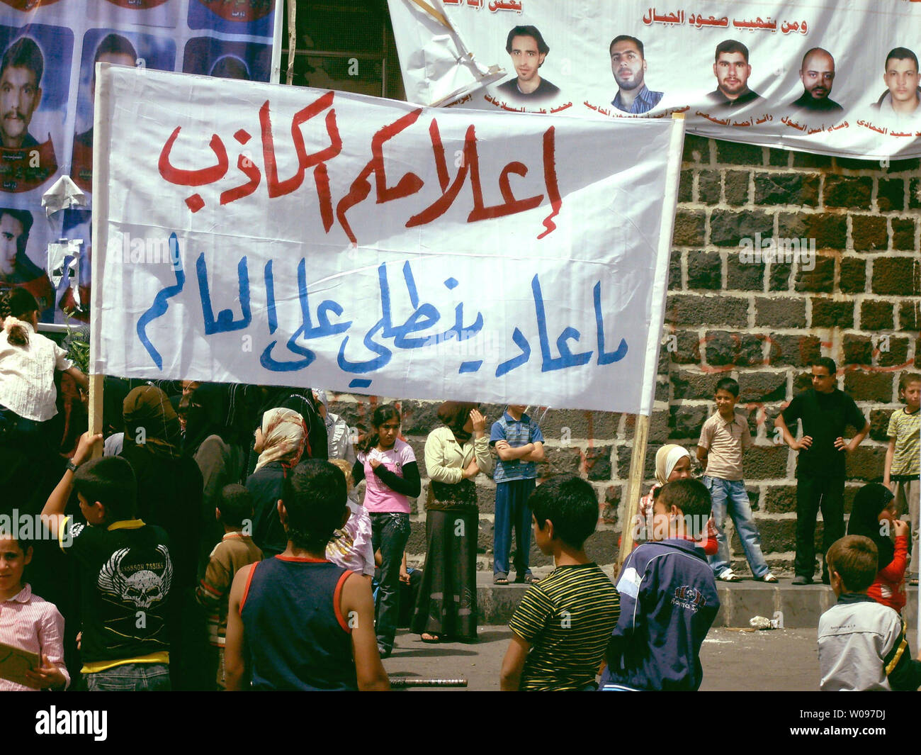Mères, épouses, soeurs et enfants contre le gouvernement syrien d'hommes qui ont été arrêtés par les forces de sécurité détiennent des banderoles et de crier des slogans au cours d'une manifestation exigeant de les relâcher dans la ville de Nawa, ville de Darra, la Syrie, le 4 mai 2011. UPI Banque D'Images