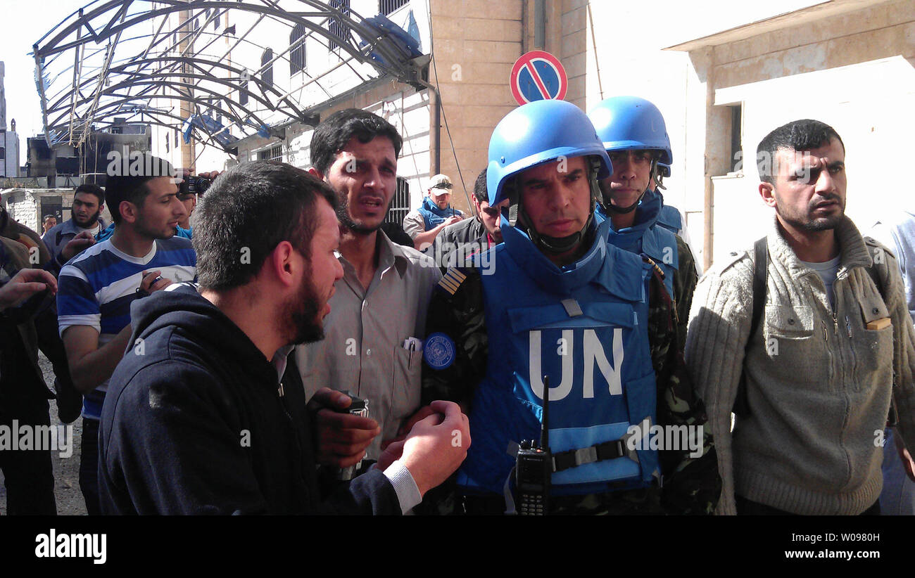 Les résidents syriens parler d'observation des Nations Unies au Maroc, le colonel Ahmed Himmiche (C), au cours de l'Organisation des Nations Unies surveille visite de la ville agitée de Homs, en Syrie le 21 avril 2012. Les deux parties dans le conflit Syrien ont été signalés à la rupture fragile cessez-le-feu de deux semaines. UPI/Khaled Tallawy Banque D'Images
