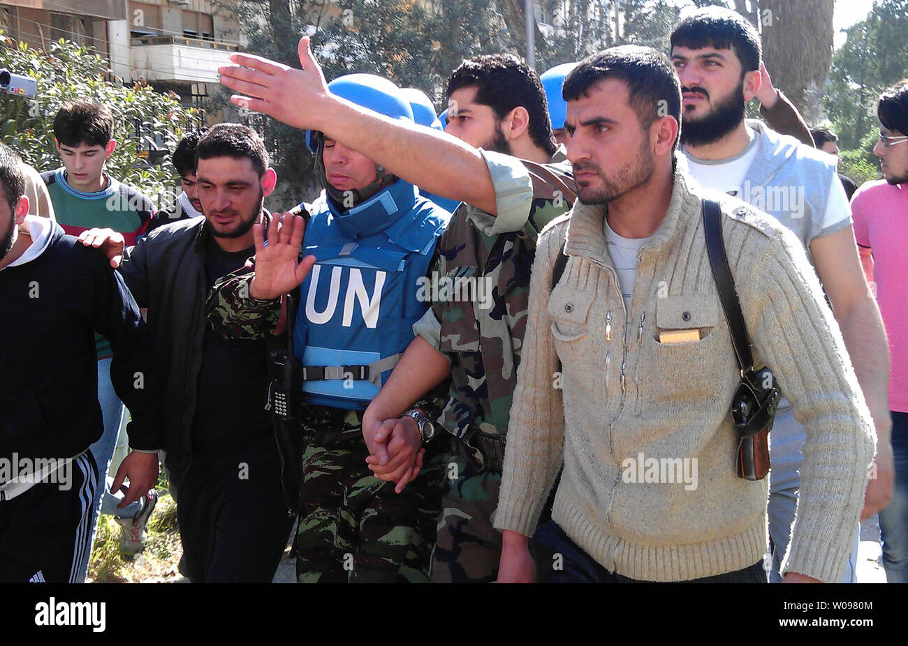 Abdul Razzaq syrien Tlas, chef de l'opposition Katibat al-Faruq, montre la voie pendant qu'il marche avec l'observation de l'ONU, le Colonel marocain Ahmed Himmiche (C), au cours de l'Organisation des Nations Unies surveille visite de la ville agitée de Homs, en Syrie le 21 avril 2012. Les deux parties dans le conflit Syrien ont été signalés à la rupture fragile cessez-le-feu de deux semaines. UPI/Khaled Tallawy Banque D'Images