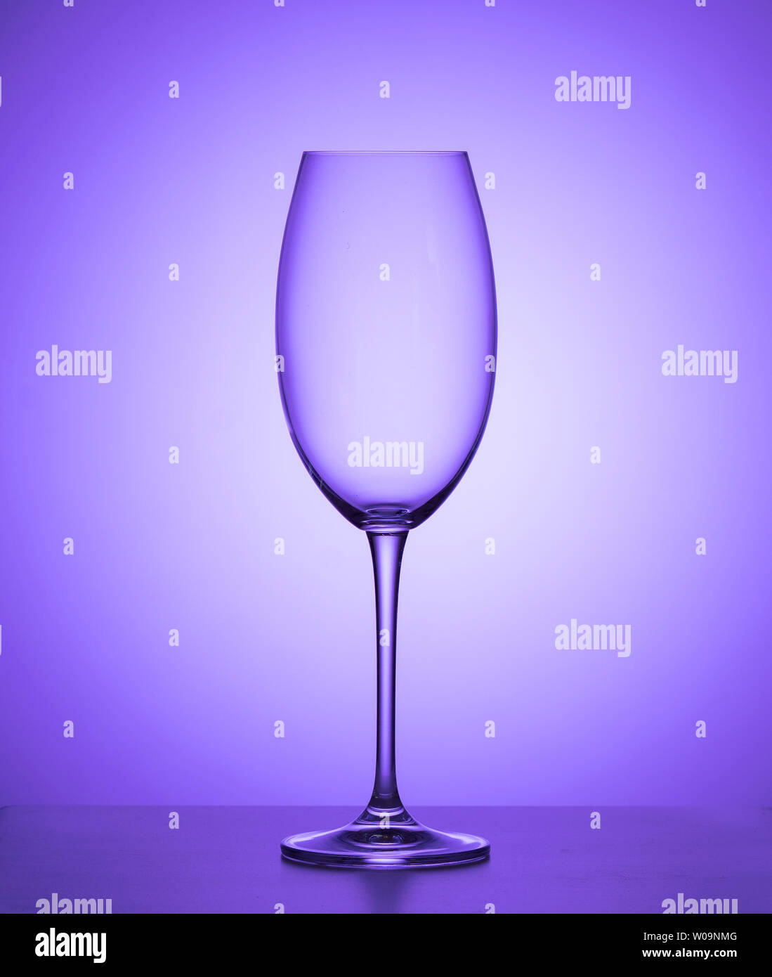 Verre de vin vide sur fond violet. close up. Banque D'Images
