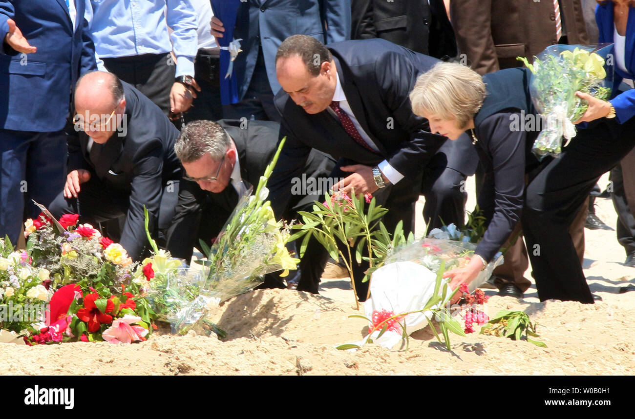 (L À R ) Le Ministre français de l'intérieur Bernard Cazeneuve, Ministre allemand de l'intérieur Thomas de Maizière, ministre de l'intérieur tunisien Mohamed Najem Gharsalli et de l'Intérieur britannique Theresa peut déposer des fleurs qu'ils paient leurs égards devant un mémorial de fortune de la plage de l'hôtel Imperial Marhaba resort, qui a été attaqué il y a trois jours par un tireur (ISIS) dans la région de Sousse, Tunisie, 29 juin 2015.L'État islamique (ISIS) groupe n'a revendiqué la responsabilité pour le massacre le 27 juin dans une attaque mortelle beach resort qui a tué près de 40 personnes, pour la plupart des touristes britanniques. Photo par Khaled Nasraoui/UP Banque D'Images