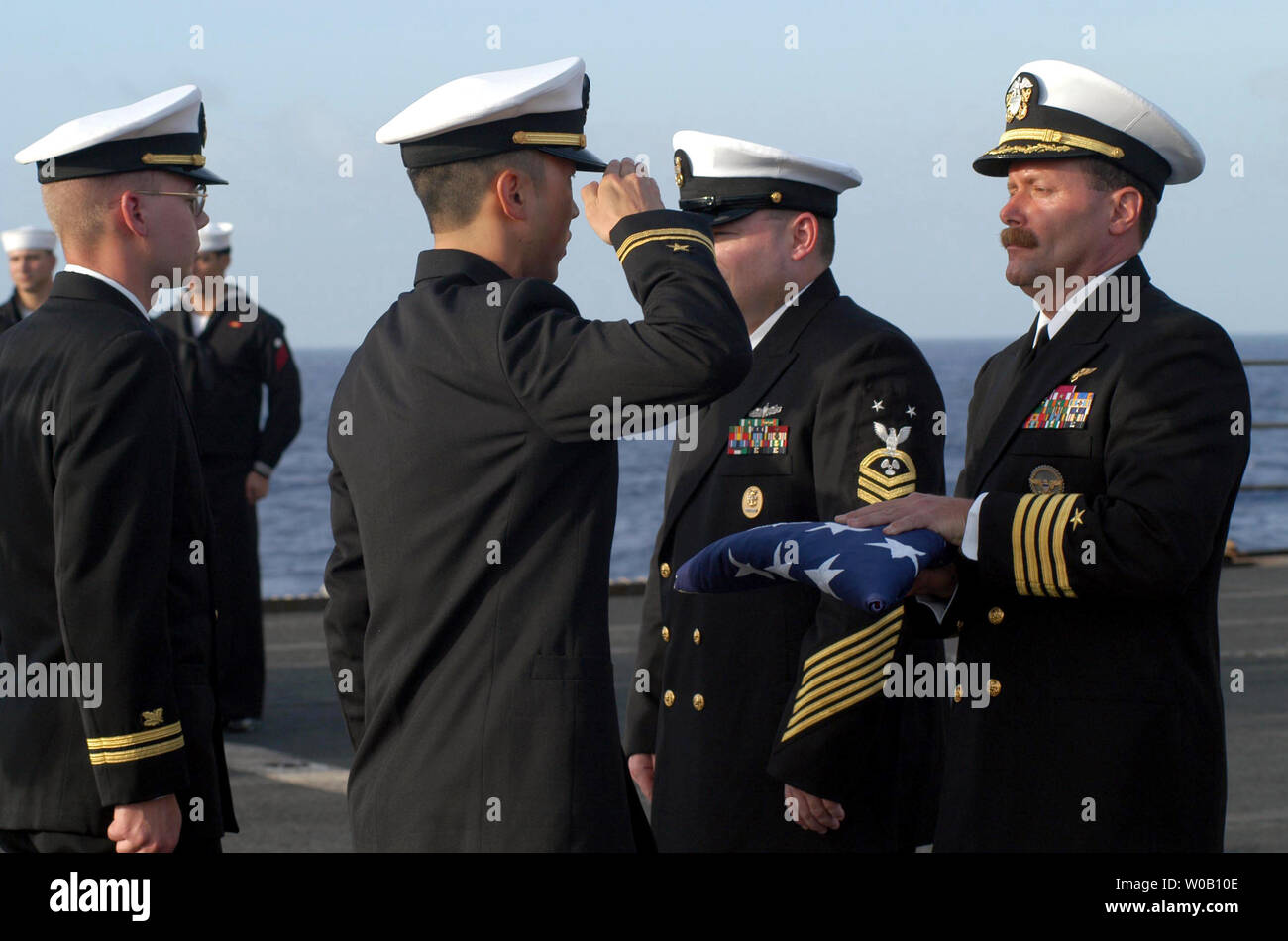 NAV2003041611-USS SACRAMENTO, l'océan Pacifique, le 15 avril (UPI)-- Le Capitaine Michael C. Manazir, Commandant de l'appui au combat rapide USS Sacramento (AOE 1), est saluée par un porteur de drapeau au cours d'une cérémonie d'inhumation en mer. L'inhumation en mer est un moyen de traitement final de reste c'est effectué sur les navires de la marine des États-Unis. Sacramento est actuellement en déploiement avec l'USS Carl Vinson Carrier Strike Force dans l'ouest de l'océan Pacifique. jg/nvns/photographe 4400 3e classe Martin S. Fuentes UPI Banque D'Images