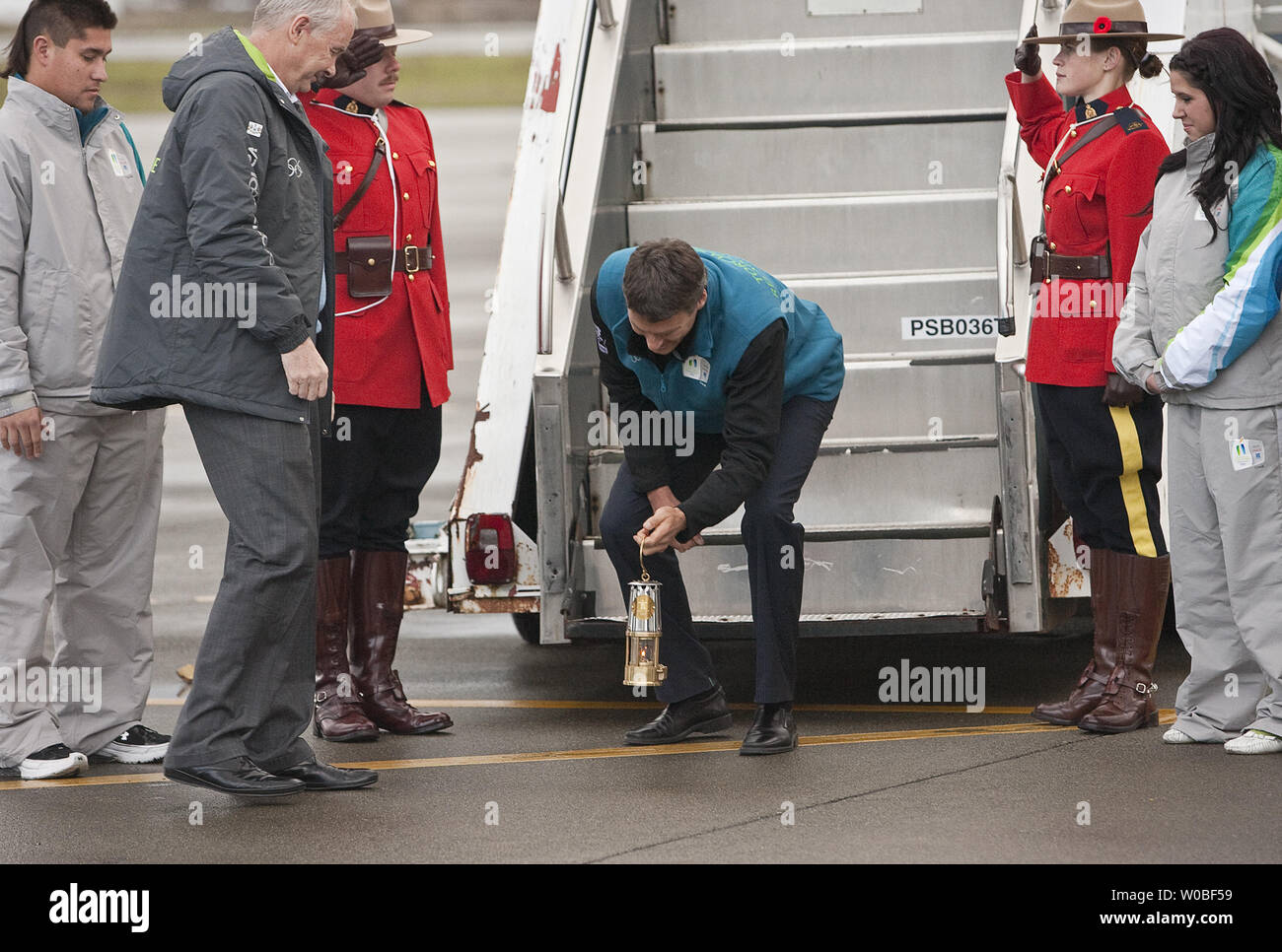 Directeur général du COVAN, John Furlong, observe le maire de Vancouver, Gregor Robertson abaisser la flamme olympique dans une lanterne mineurs de toucher le sol canadien après qu'il en débarque un CC 150 Polaris (Airbus A-310) des aéronefs à l'arrivée d'Athènes, la Grèce à l'Aéroport International de Victoria où le premier ministre canadien Stephen Harper, en Colombie-Britannique (C.-B.) Le Premier ministre Gordon Campbell et d'autres dignitaires attendre d'accueillir la flamme au Canada pour le début de l'hiver 2010 Relais de la flamme olympique à Victoria, C.-B., le 30 octobre 2009. UPI /Heinz Ruckemann Banque D'Images