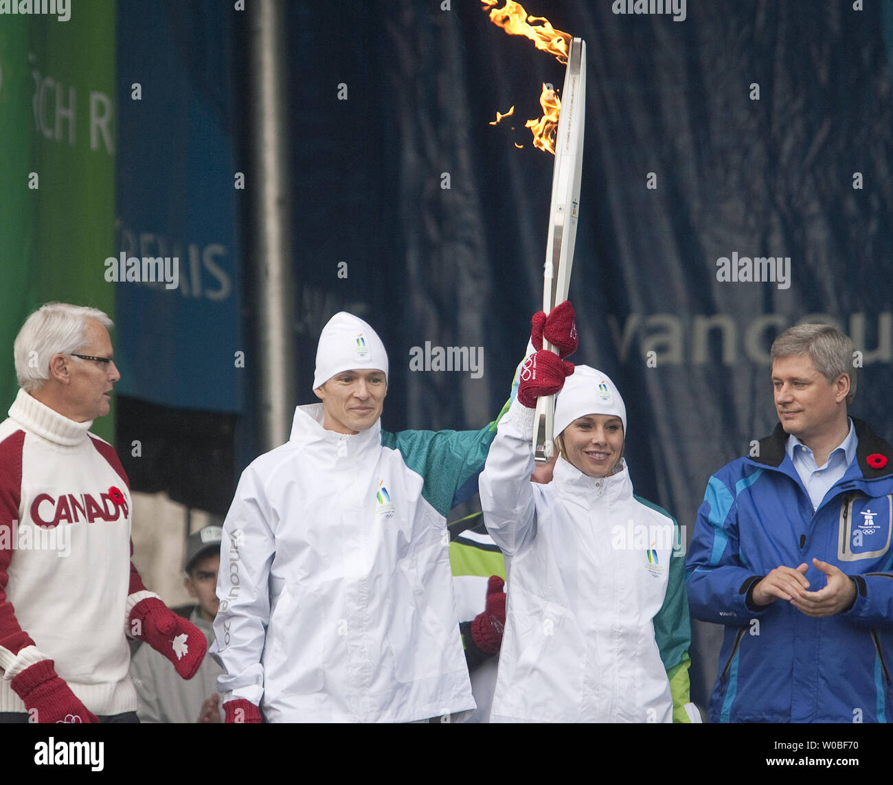 La Colombie-Britannique (C.-B.) Le Premier ministre Gordon Campbell (L) et le premier ministre canadien Stephen Harper (R) Regardez le premier flambeau de la flamme olympique d'hiver de 2010, qui a remporté la médaille d'or de Simon Whitfield Olympiens (L, Triathlon) et Catriona Le May Doan (patinage de vitesse) hold up leur flambeau après qu'elle a été allumée à partir de la flamme olympique dans la célébration communautaire de 1,2 mètre au chaudron l'Assemblée législative de la Colombie-Britannique à Victoria, C.-B., le 30 octobre 2009. UPI /Heinz Ruckeman Banque D'Images
