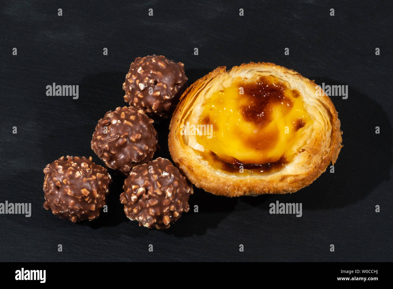 Tarte au citron crème anglaise avec 4 boules de crème glacée au chocolat noisette servi sur une plaque noire servant prévue Banque D'Images