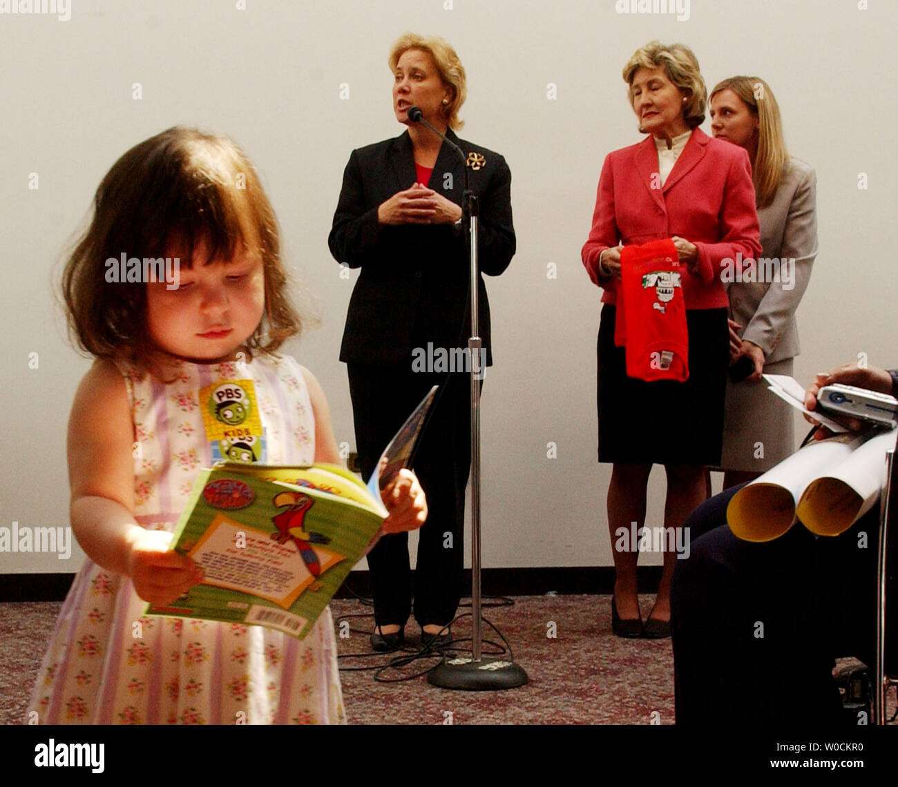 Un enfant lit un livre alors que le sénateur Kay Bailey Hutchison, R-Texas, droite, et le sénateur Mary Landrieu, D-La, parlent de leur métier au cours d'une célébration de la 12e édition de prendre nos filles et fils de travailler de jour le 28 avril 2005 à Washington. Les deux sénateurs ont parlé avec les enfants à propos de ce que c'était que de travailler au Congrès. (Photo d'UPI/Michael Kleinfeld) Banque D'Images