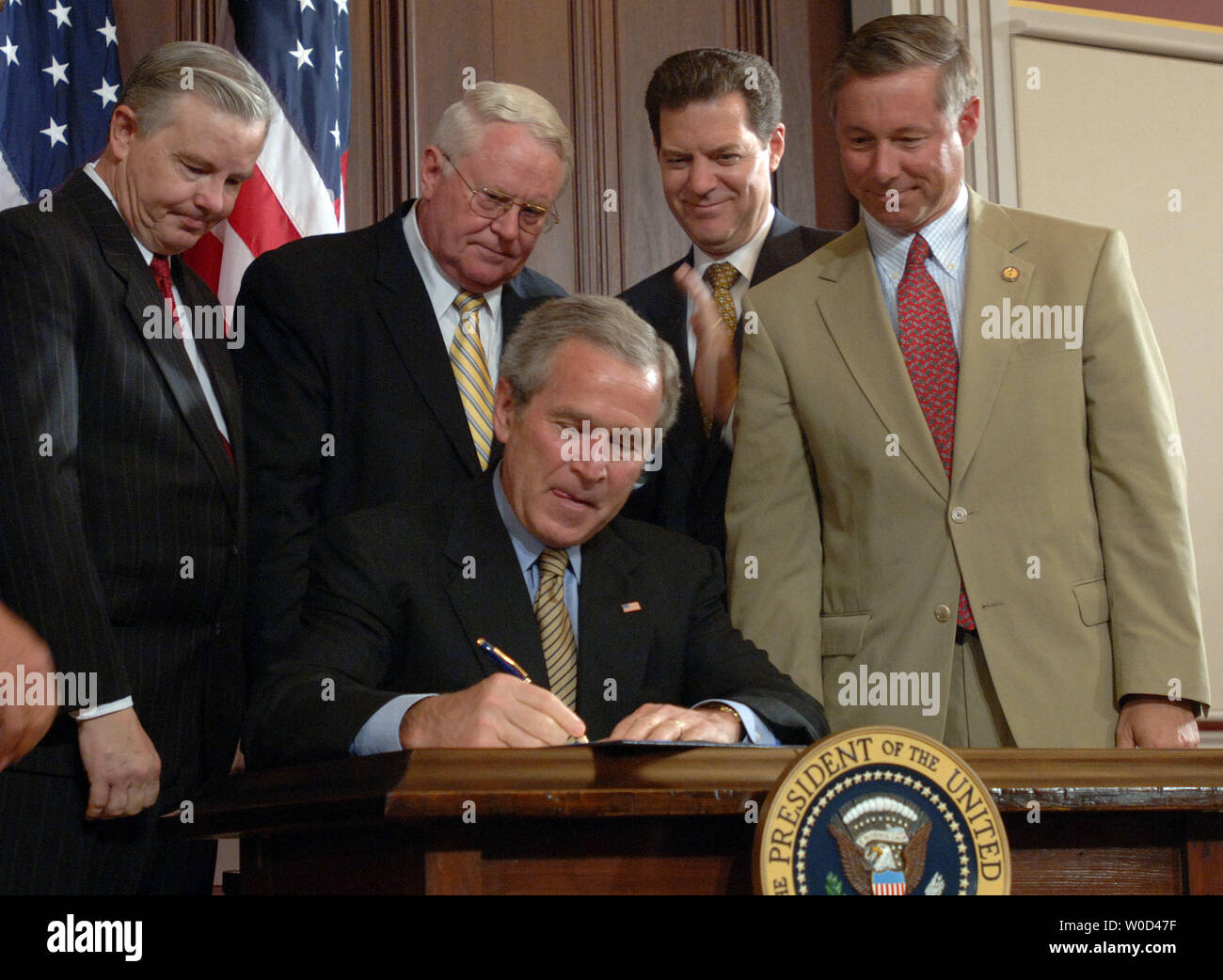 Le président américain George W. Bush signe la Loi sur l'exécution de la décence de diffusion en 2005 Le Eisenhower Executive Office Building adjacent à la Maison Blanche à Washington le 15 juin 2006. Derrière Bush sont Rempl. Joe Barton, R-TX, Rép. Joe Pitts, R-PA, le sénateur Sam Brownback, R-KS, et Fred Upton, Rép. R-MI. (L ) (UPI/Photo Roger L. Wollenberg) Banque D'Images