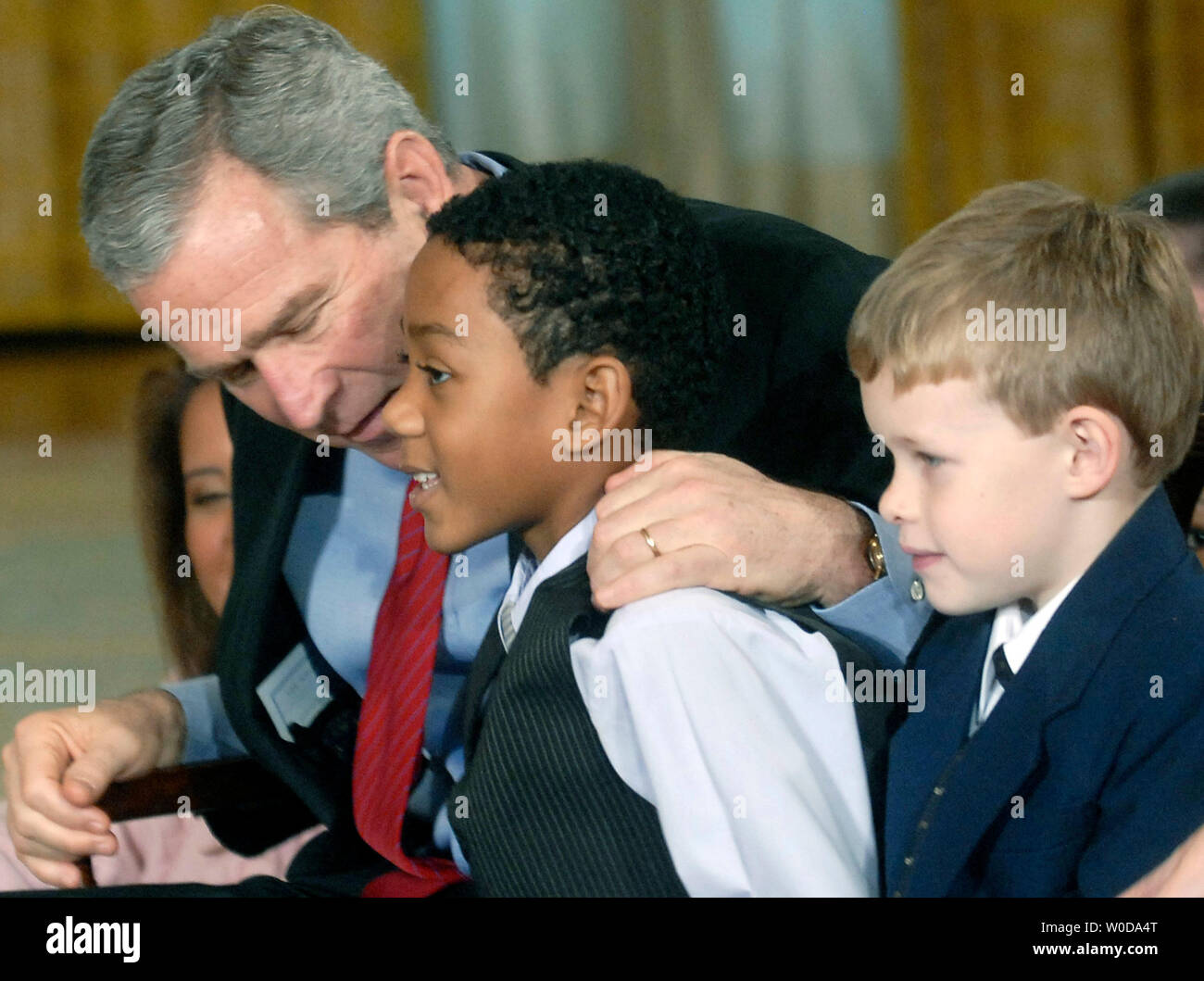 Le président américain George W. Bush parle à Addis Bugg, 8 (L) alors que Chauncey Liscomb, 7 se trouve sur le flanc, lors d'une performance de Willy Wonka et l'usine de chocolat, à la maison de l'enfance de la réception et des performances, à la Maison Blanche à Washington le 4 décembre 2006. (UPI Photo/Kevin Dietsch) Banque D'Images